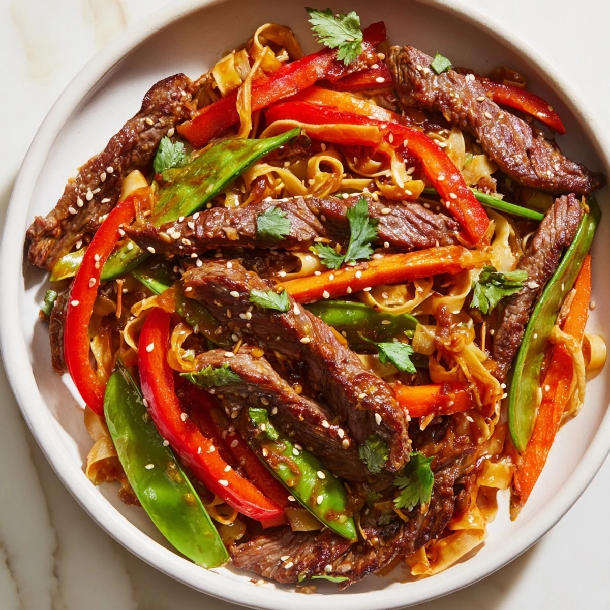 Hot Spicy Beef Stir Fry with Noodles sizzling in a wok with broccoli and bell peppers.