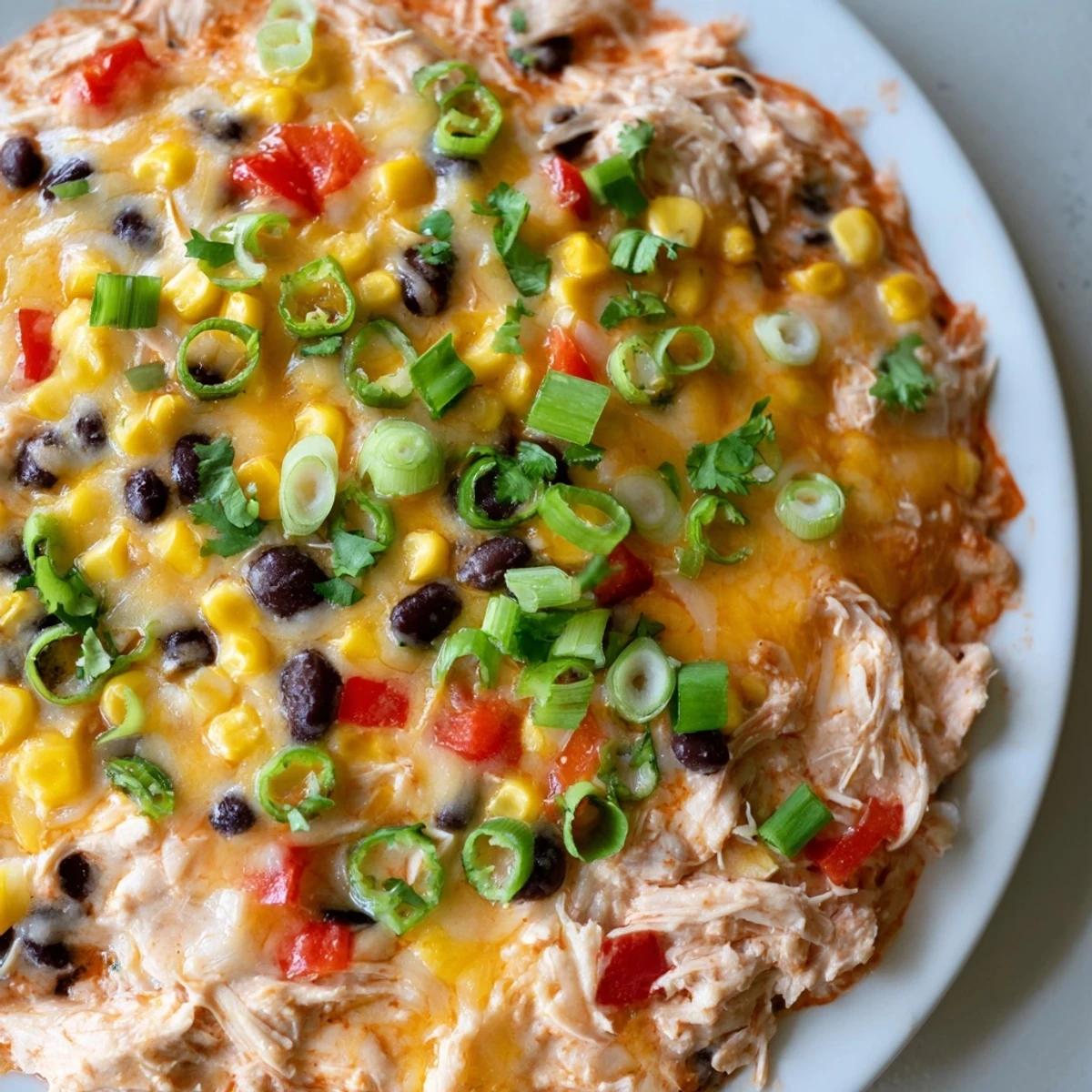 A creamy Chicken Enchilada Dip is garnished with cilantro and served with tortilla chips.