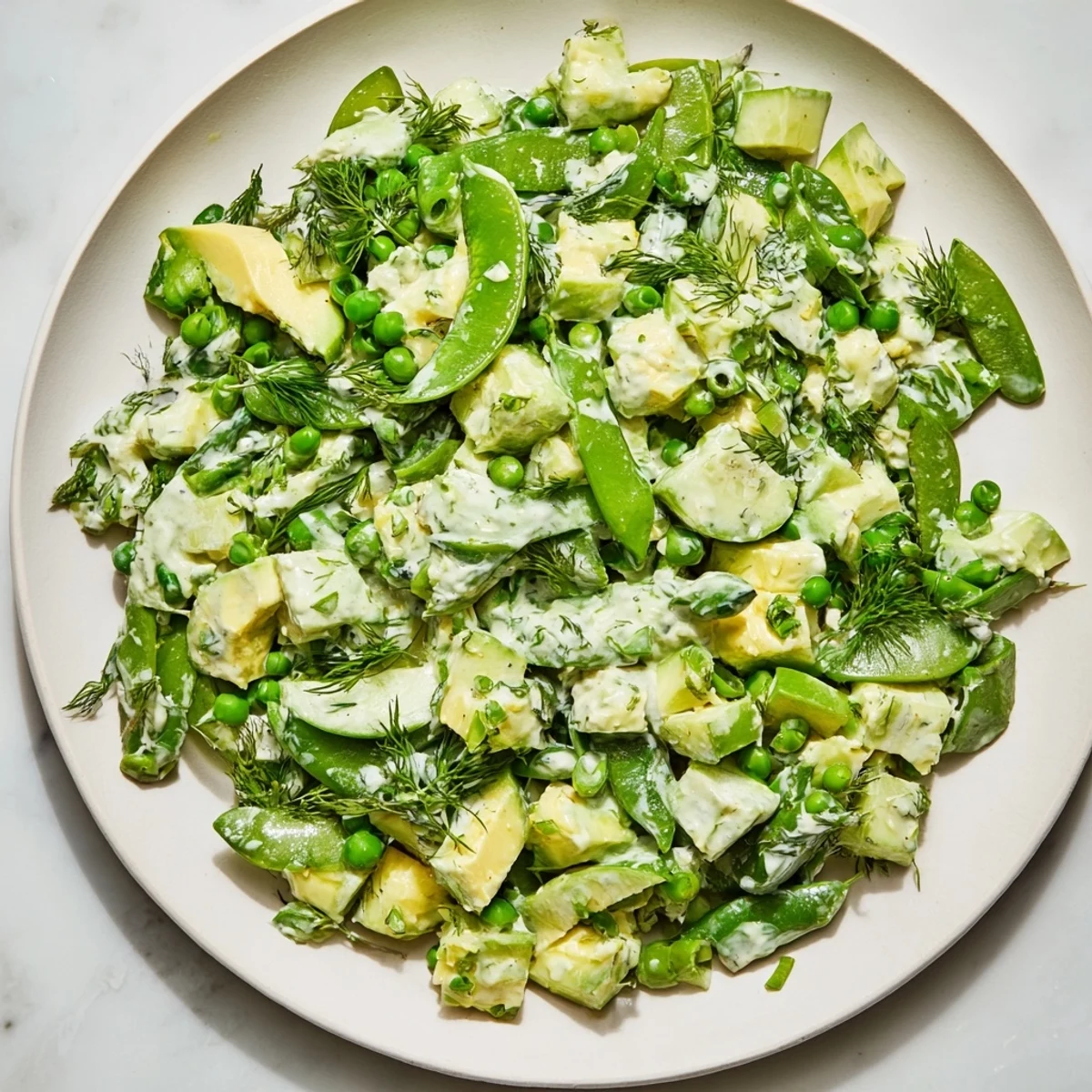 Creamy avocado and crisp cucumber chunks glisten in Green Goddess Salad with Cucumber and Avocado.