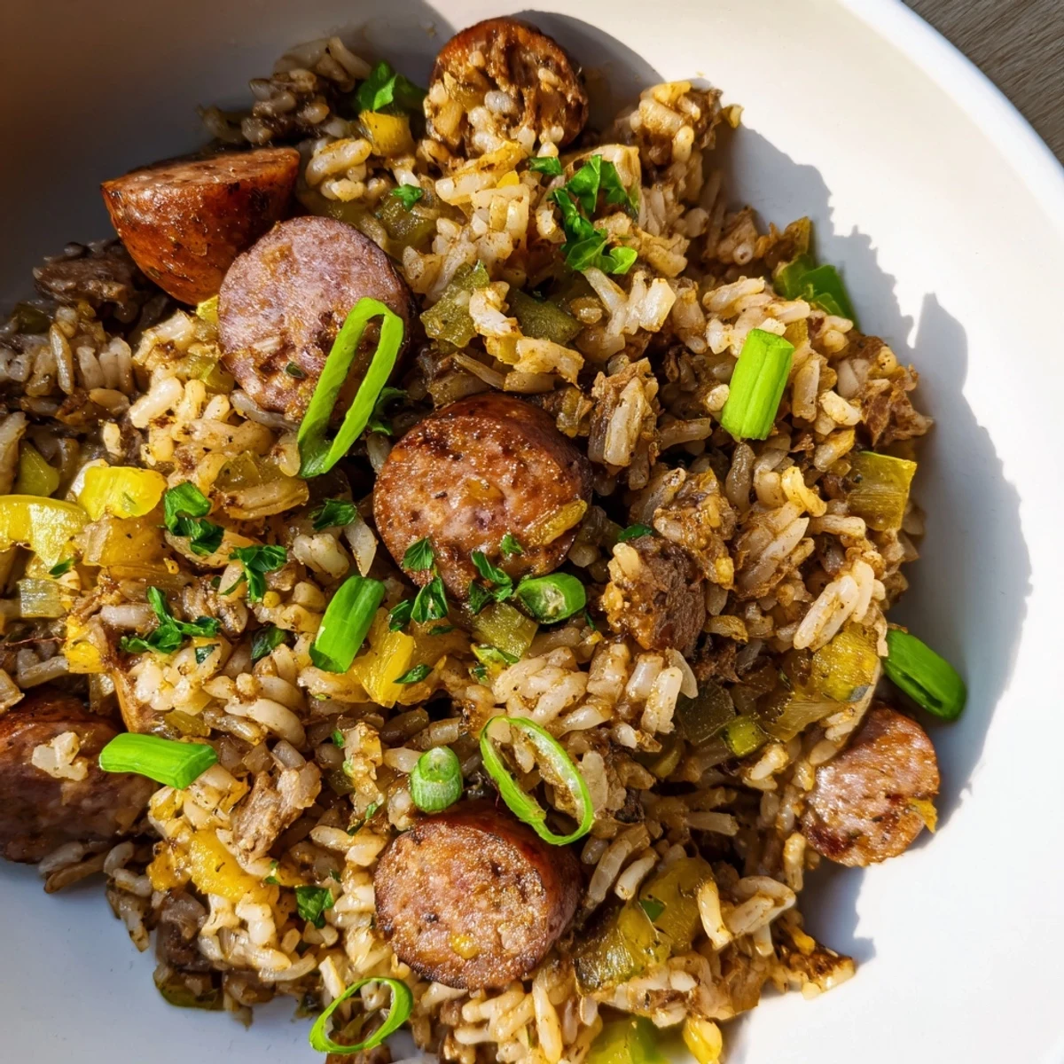 Fluffy, seasoned rice mixed with savory sausage and vegetables in a rustic skillet, showcasing this easy Mardi Gras Dirty Rice recipe.