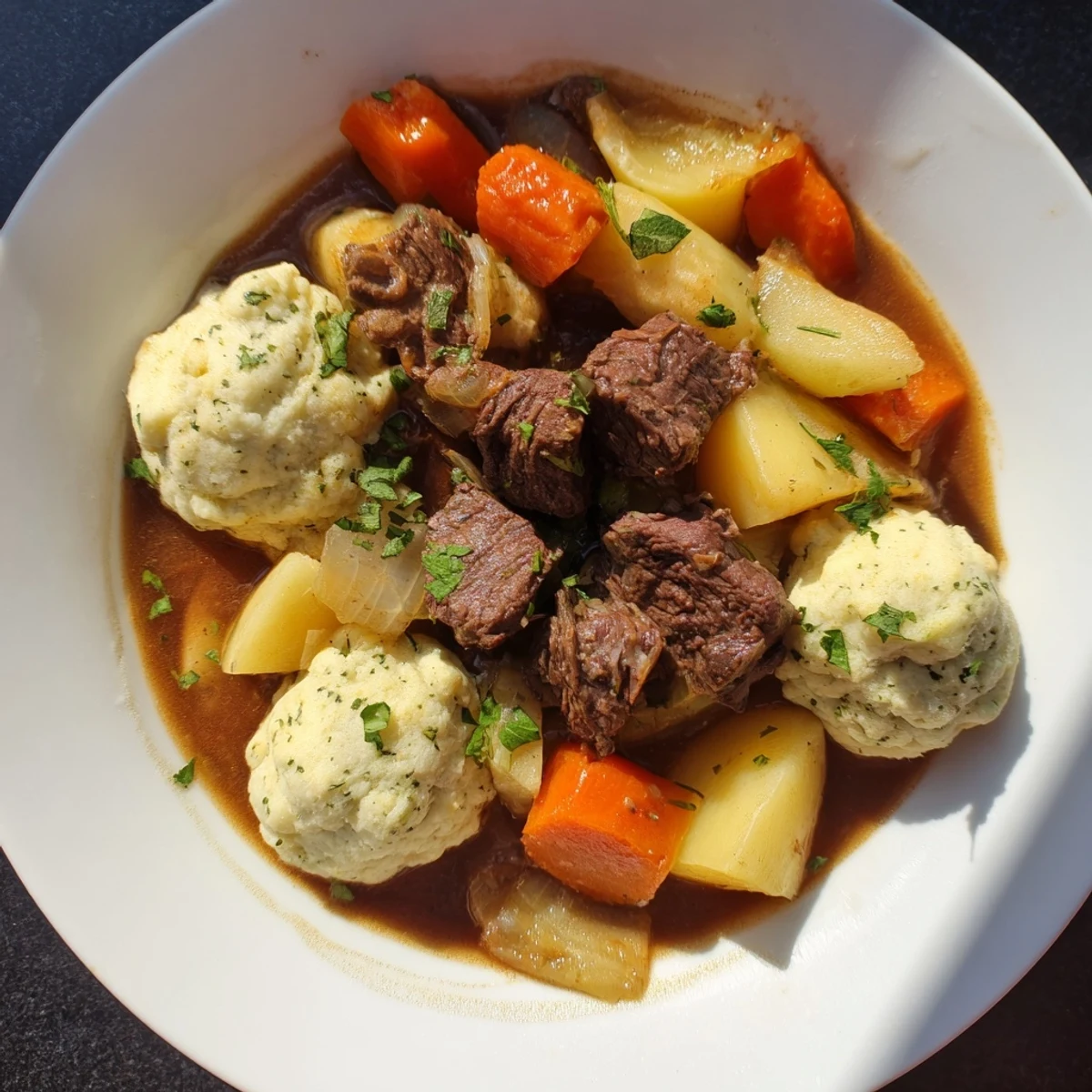 Hearty Irish Beef Stew with Dumplings served in a bowl, garnished with fresh parsley beside crusty bread.