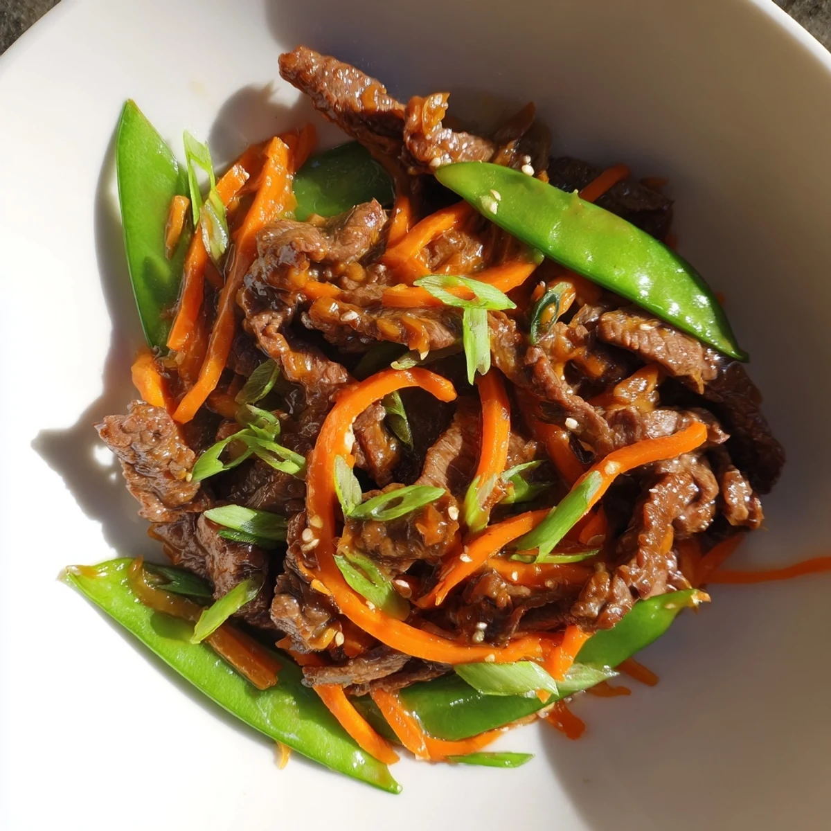 Freshly cooked Beef Stir Fry with Snow Peas and Carrots served hot over fluffy white rice.