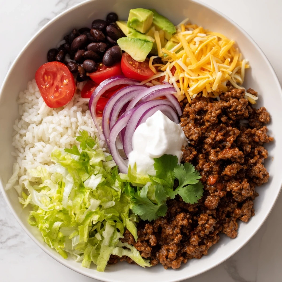 A vibrant Beef Burrito Bowls with Rice and Beans features seasoned ground beef, fluffy rice, and creamy avocado in colorful bowls.