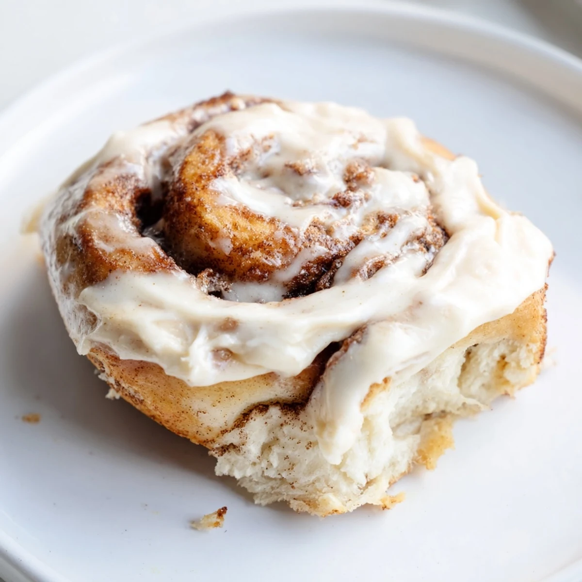 Warm Keto Cinnamon Buns with cream cheese icing on a wooden board, close-up view.
