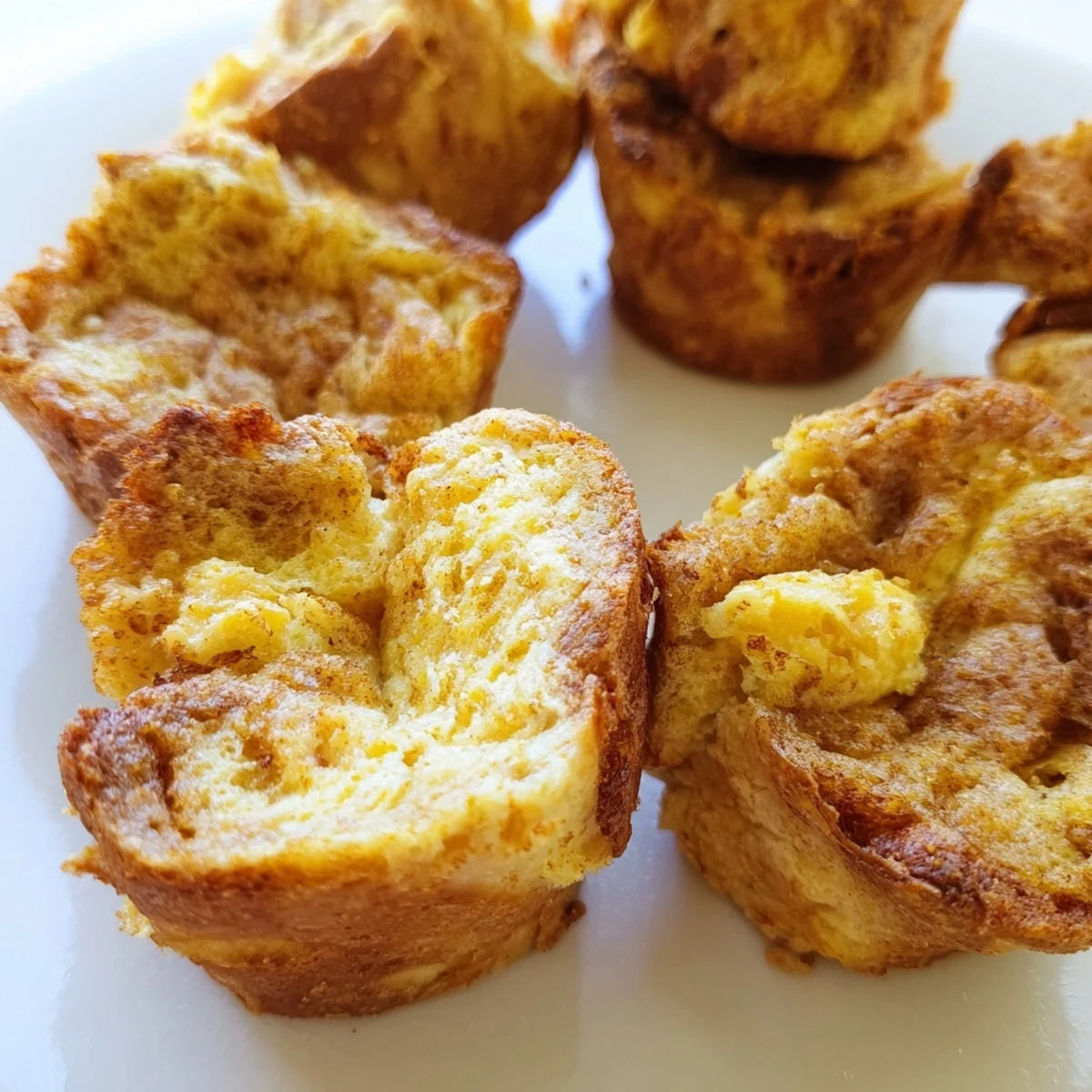 Golden-brown Protein French Toast Muffins sit on a wooden board, ready to be enjoyed warm for a quick high-protein breakfast.