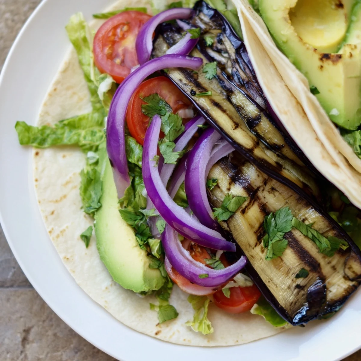 Charred Eggplant Tacos with smoky grilled slices, fresh lettuce, and avocado on warm tortillas