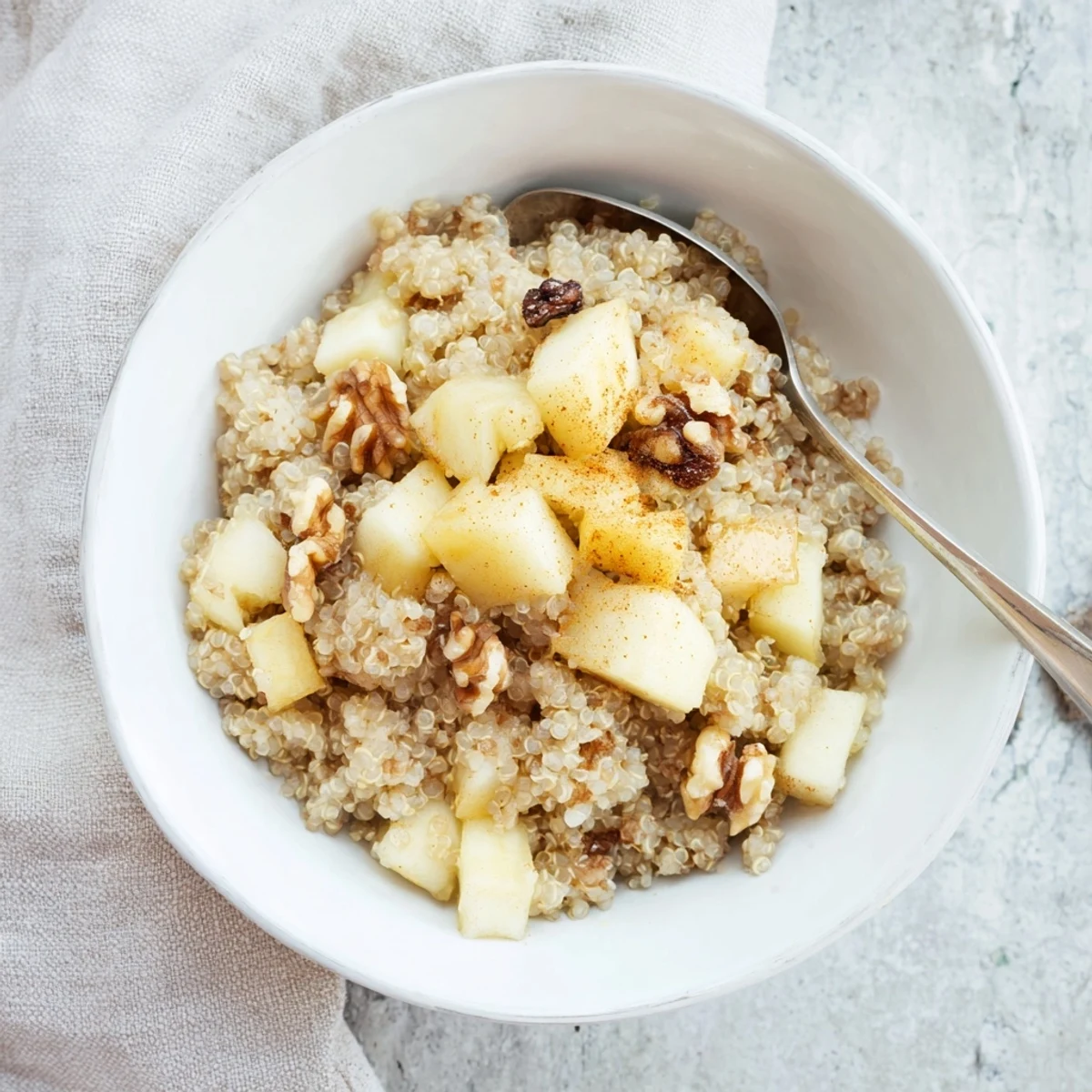 A wholesome serving of Healthy Quinoa Apple Breakfast with dried cranberries and pecans on a cozy morning.