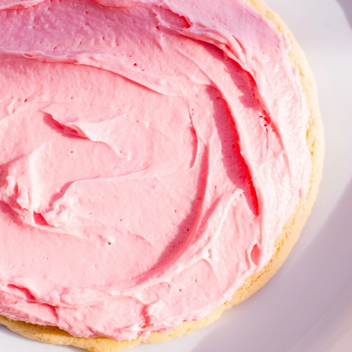 A close-up shows soft Crumbl Pink Sugar Cookies with vibrant pink frosting and a chewy center.