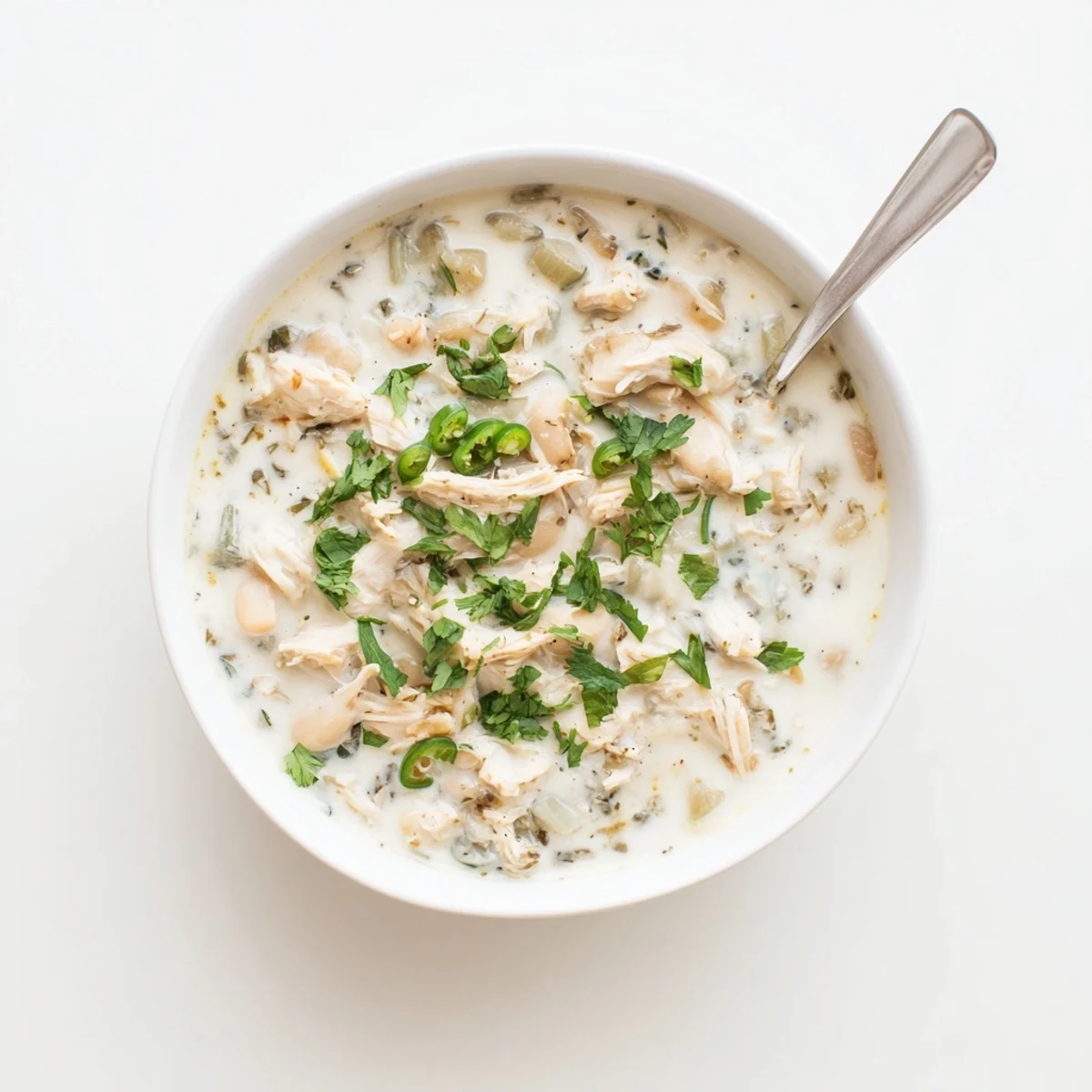 Creamy white keto chicken chili simmering with tender shredded chicken and green chiles in a rich broth