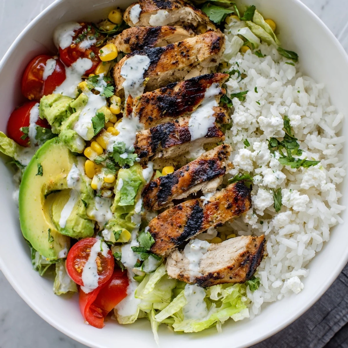 Hearty street corn chicken bowl packed with seasoned grilled chicken, sweet roasted corn, crisp lettuce, ripe avocado, and tangy cotija cheese topping