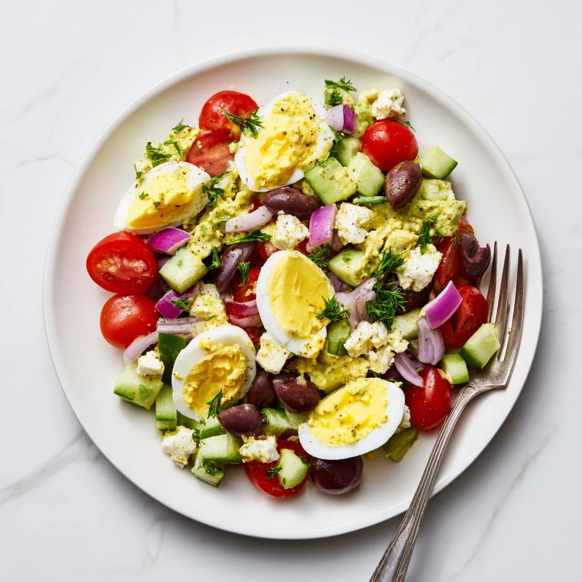 Creamy Mediterranean avocado egg salad featuring ripe avocado chunks, chopped hard-boiled eggs, and vibrant vegetables