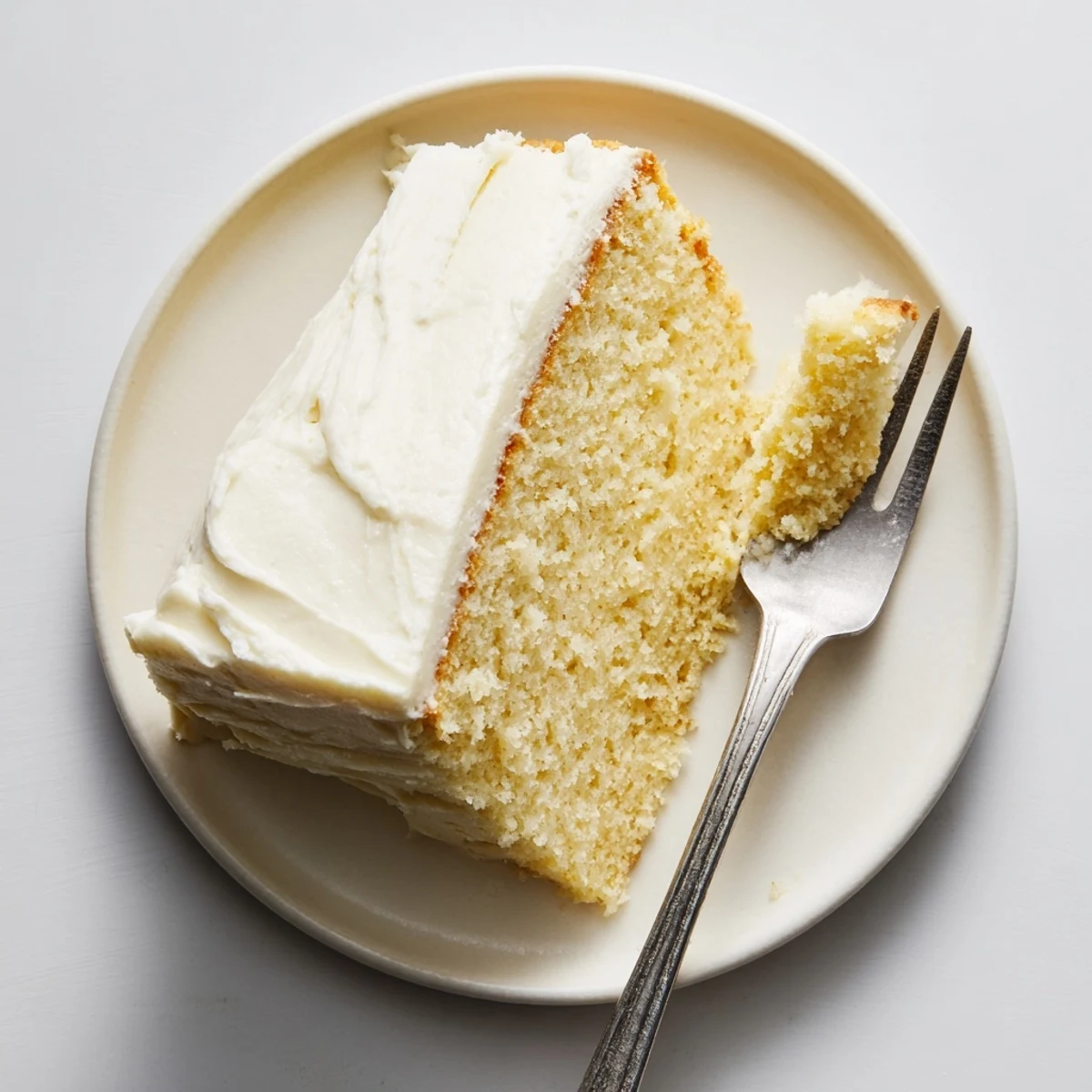 Fluffy frosted church cake served on a white platter for family gatherings