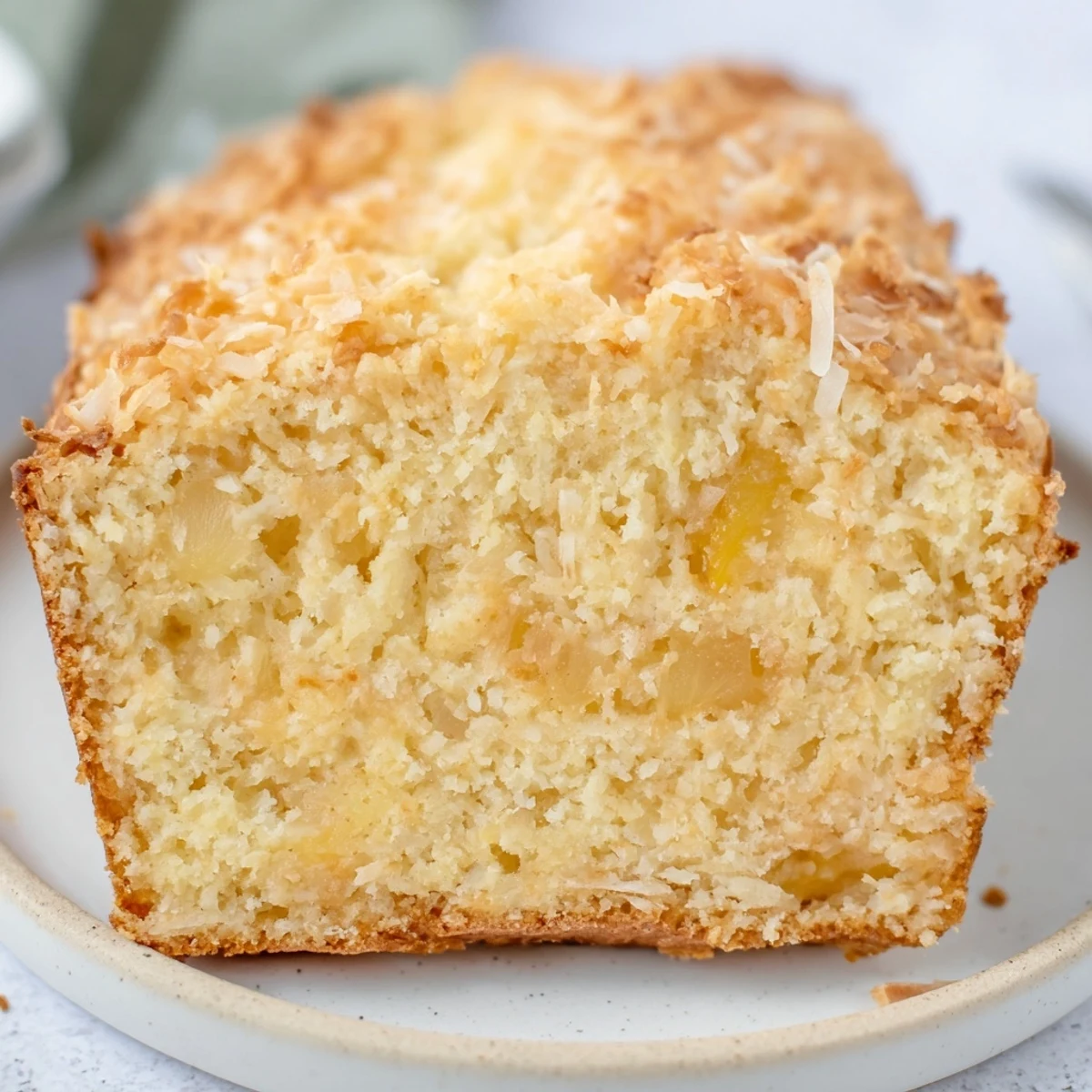 Freshly baked cozy pineapple coconut bread cooling on wire rack with toasted coconut topping