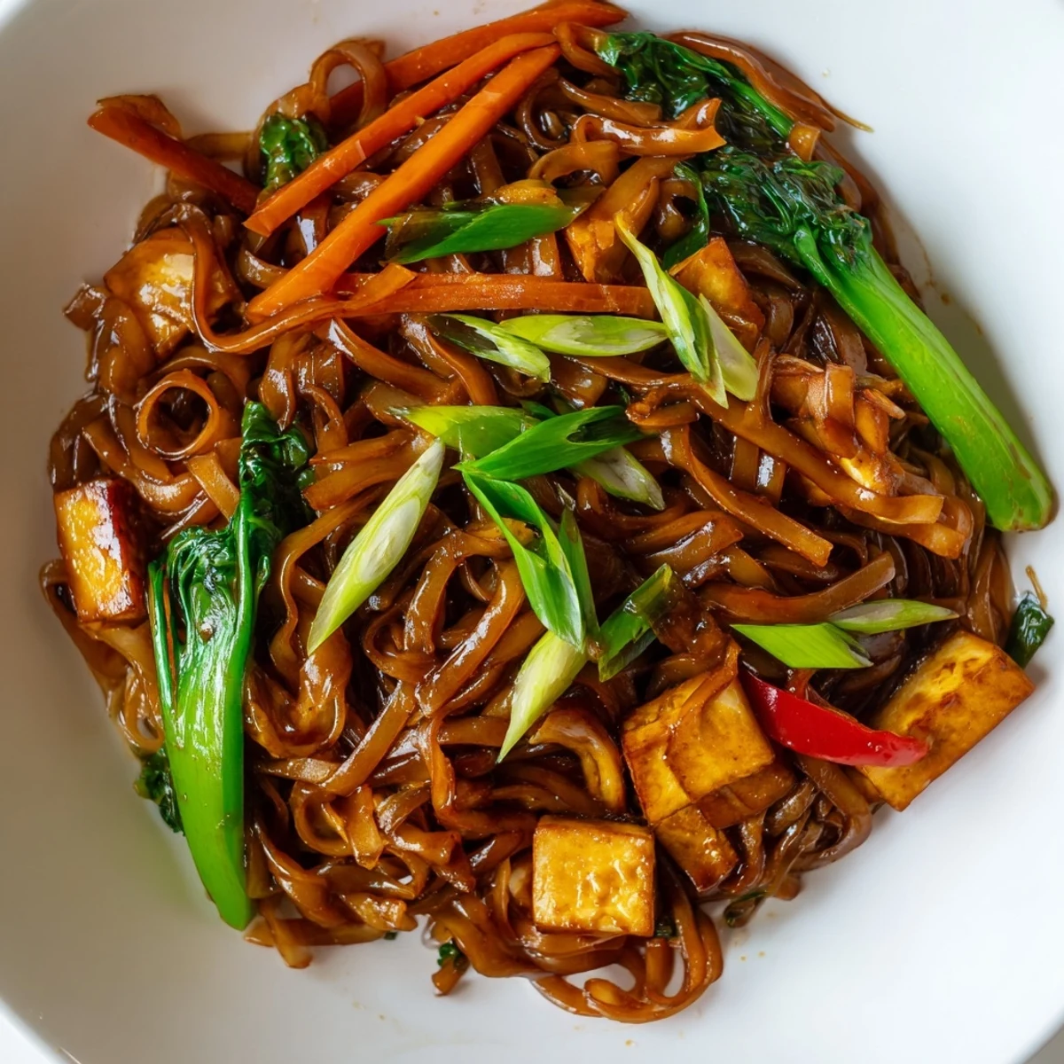 Tofu and colorful vegetables tossed with chewy rice noodles in aromatic Thai stir-fry sauce