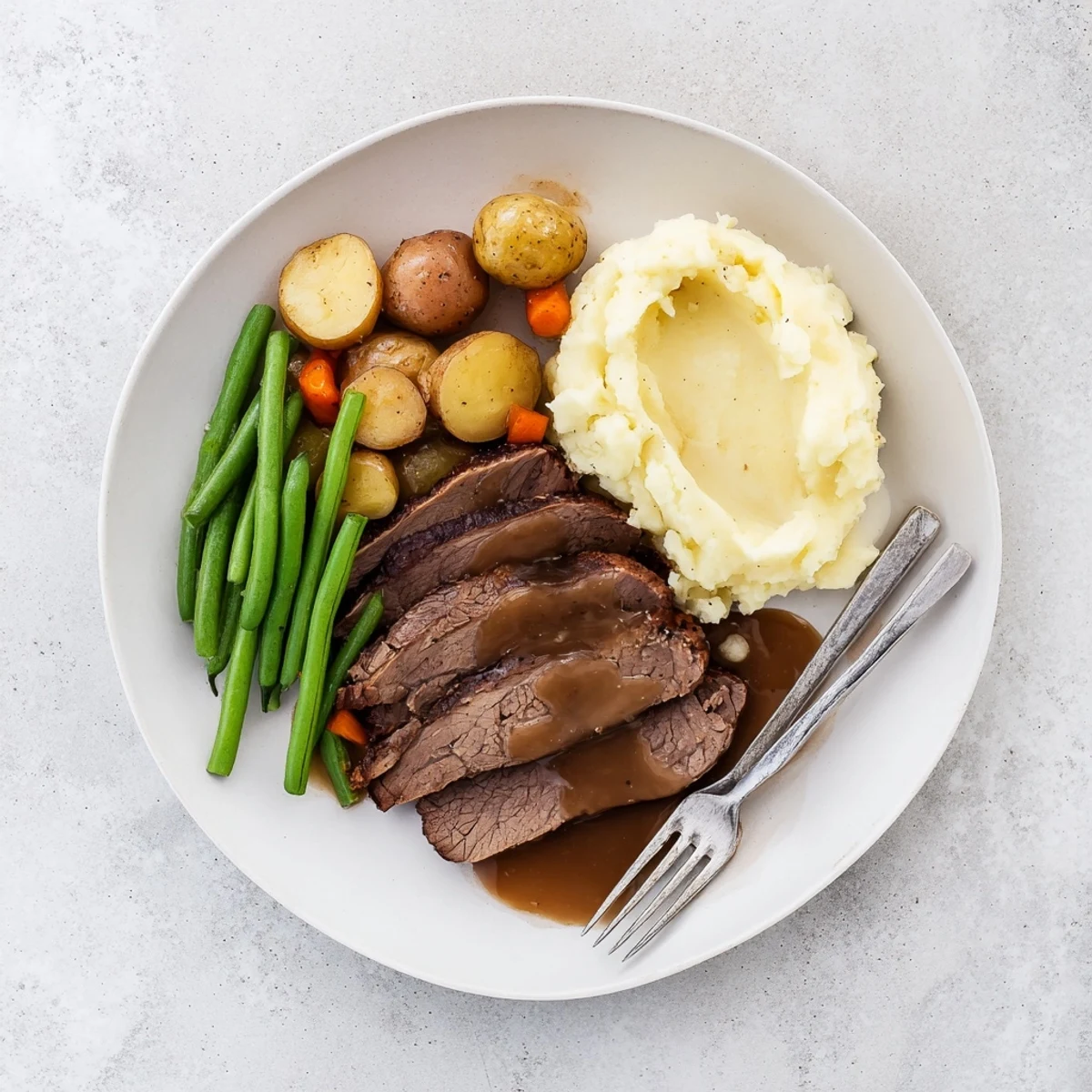Tender Southern style pot roast plate with creamy mashed potatoes and buttered green beans