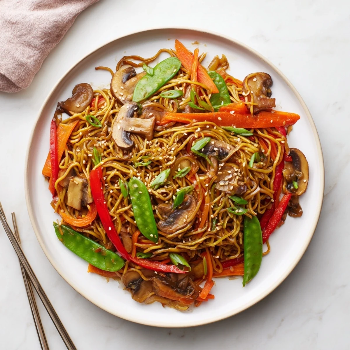 Golden egg noodles stir-fried with sliced mushrooms and crisp bell peppers in this flavorful garlic mushroom chow mein dish