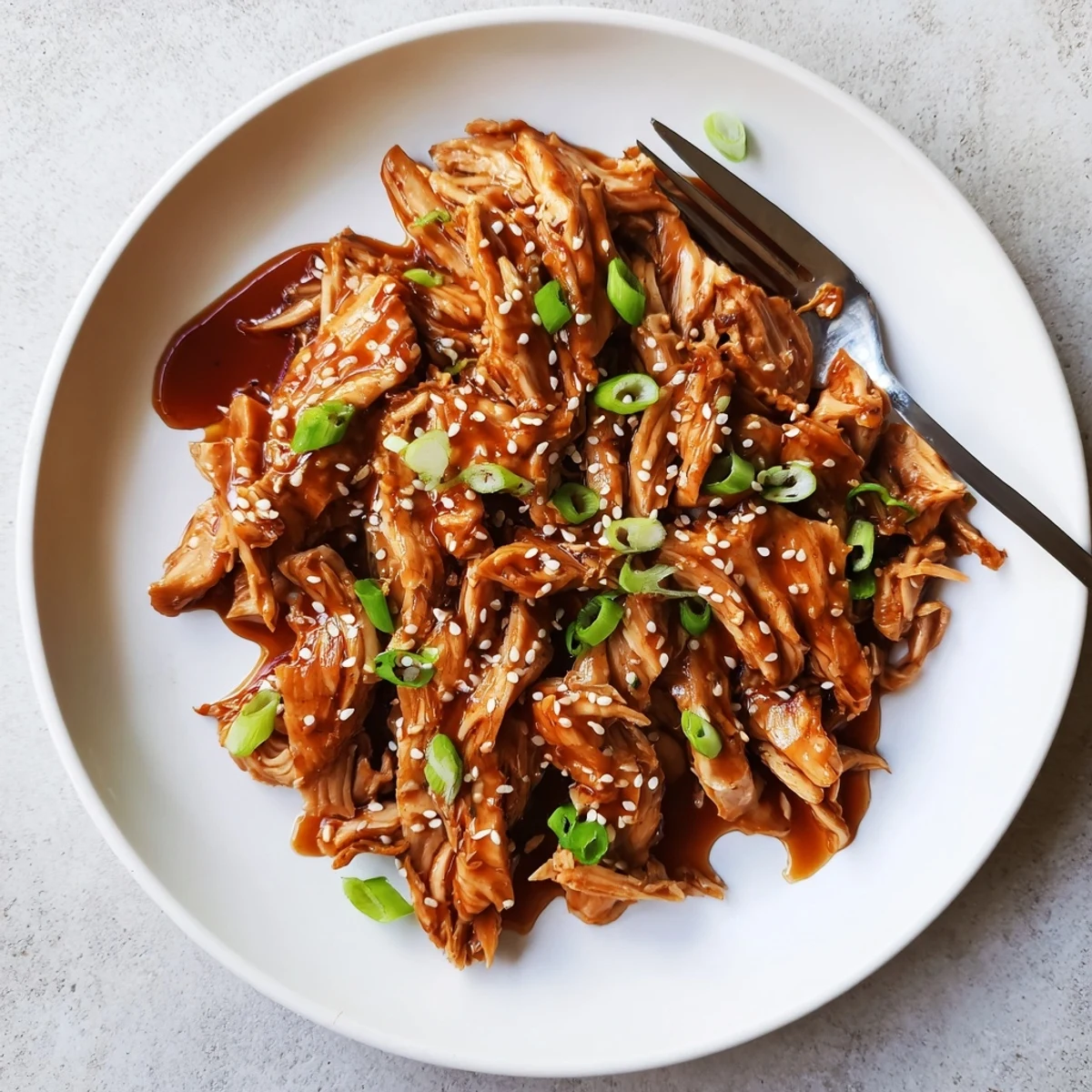 Easy Crockpot Teriyaki Chicken served in bowls with rich dark sauce and garnish