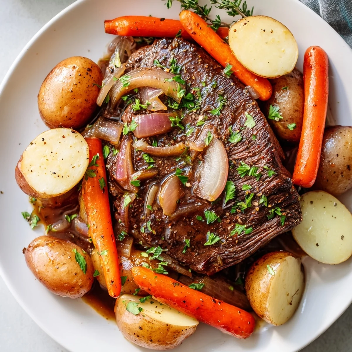 Golden slow cooker steak and potatoes with tender beef, baby carrots, and onions in rich broth