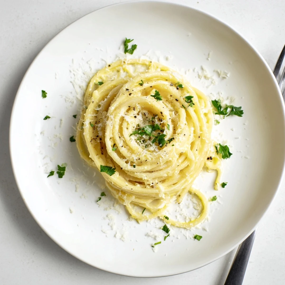 Creamy Parmesan lemon pasta tossed with garlic and olive oil in a skillet