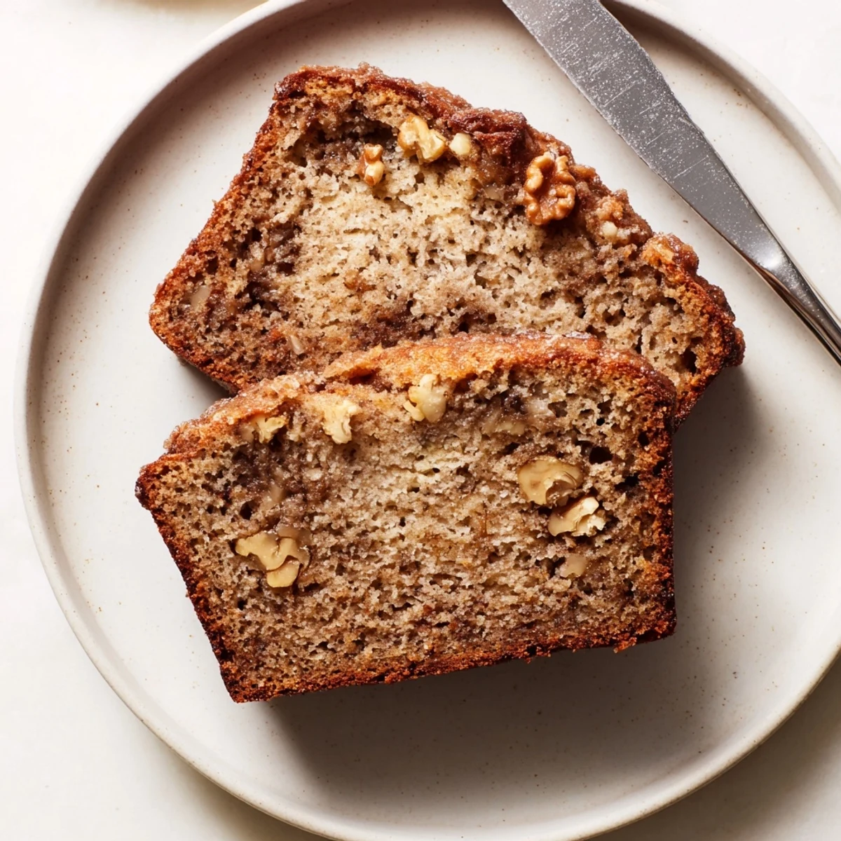 Golden super moist banana bread loaf fresh from oven with cracked sugary top