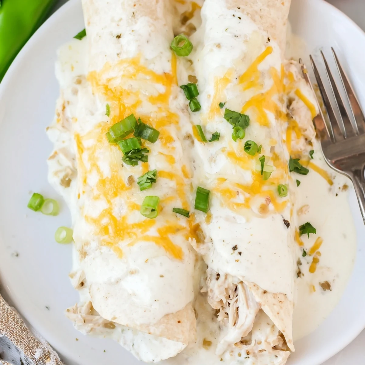Warm Creamy White Chicken Enchiladas sliced, revealing tender shredded chicken and gooey cheese