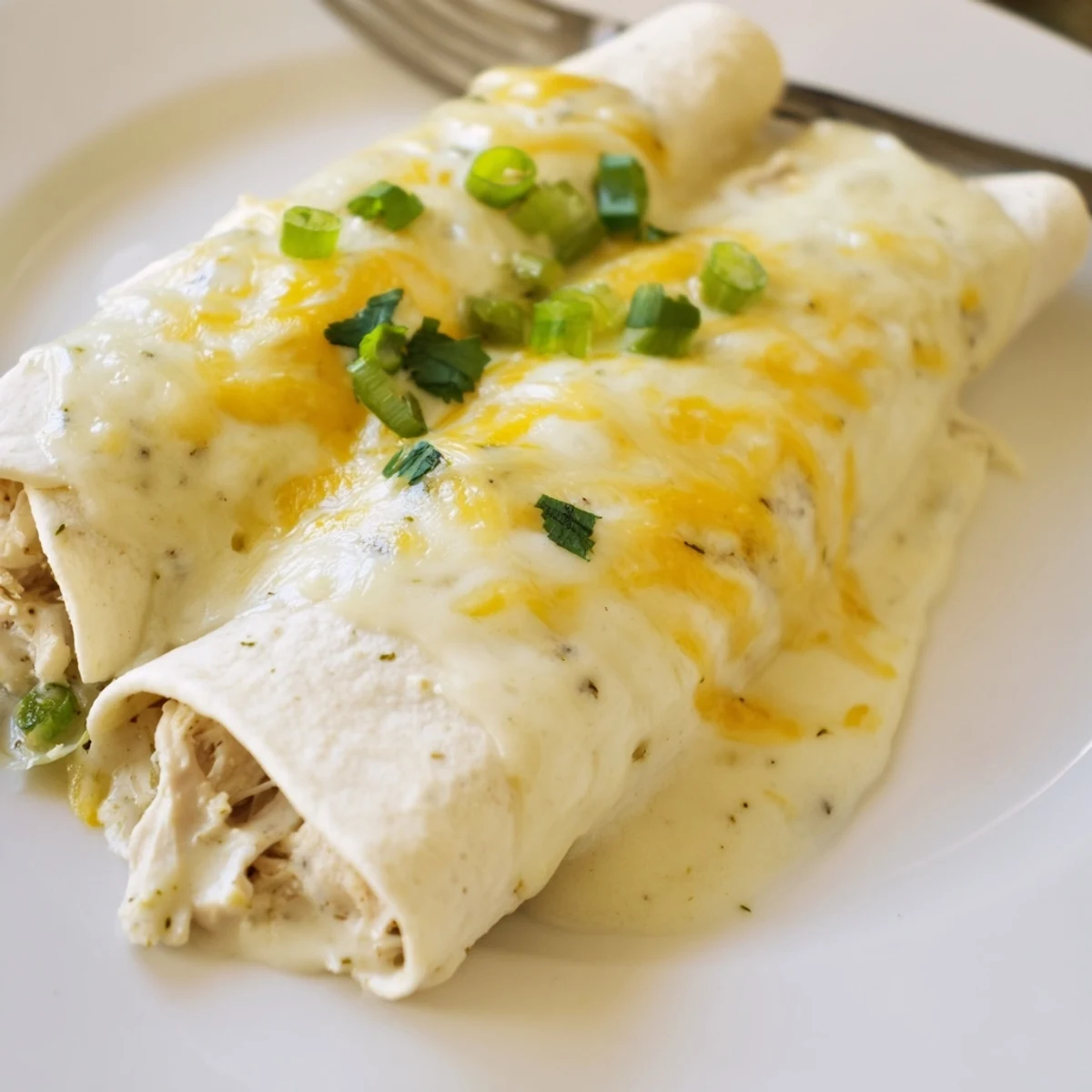Weeknight-ready Creamy White Chicken Enchiladas served hot with cilantro and Spanish rice