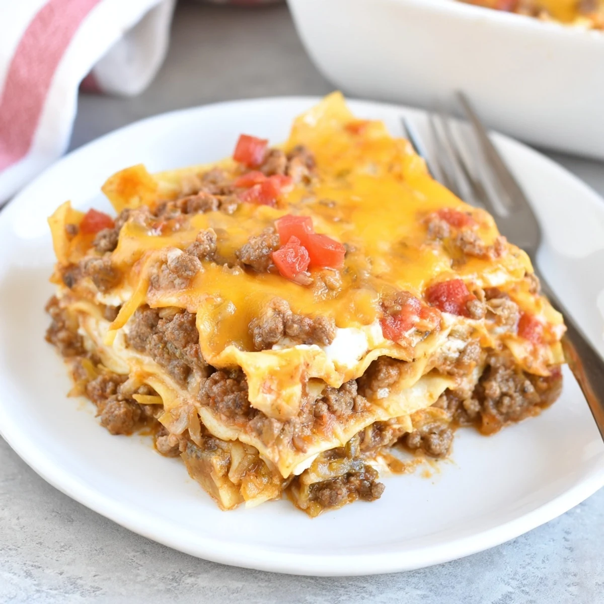 Beef Lombardi Casserole bubbling golden, cheddar crust and tomato-scented beef layers