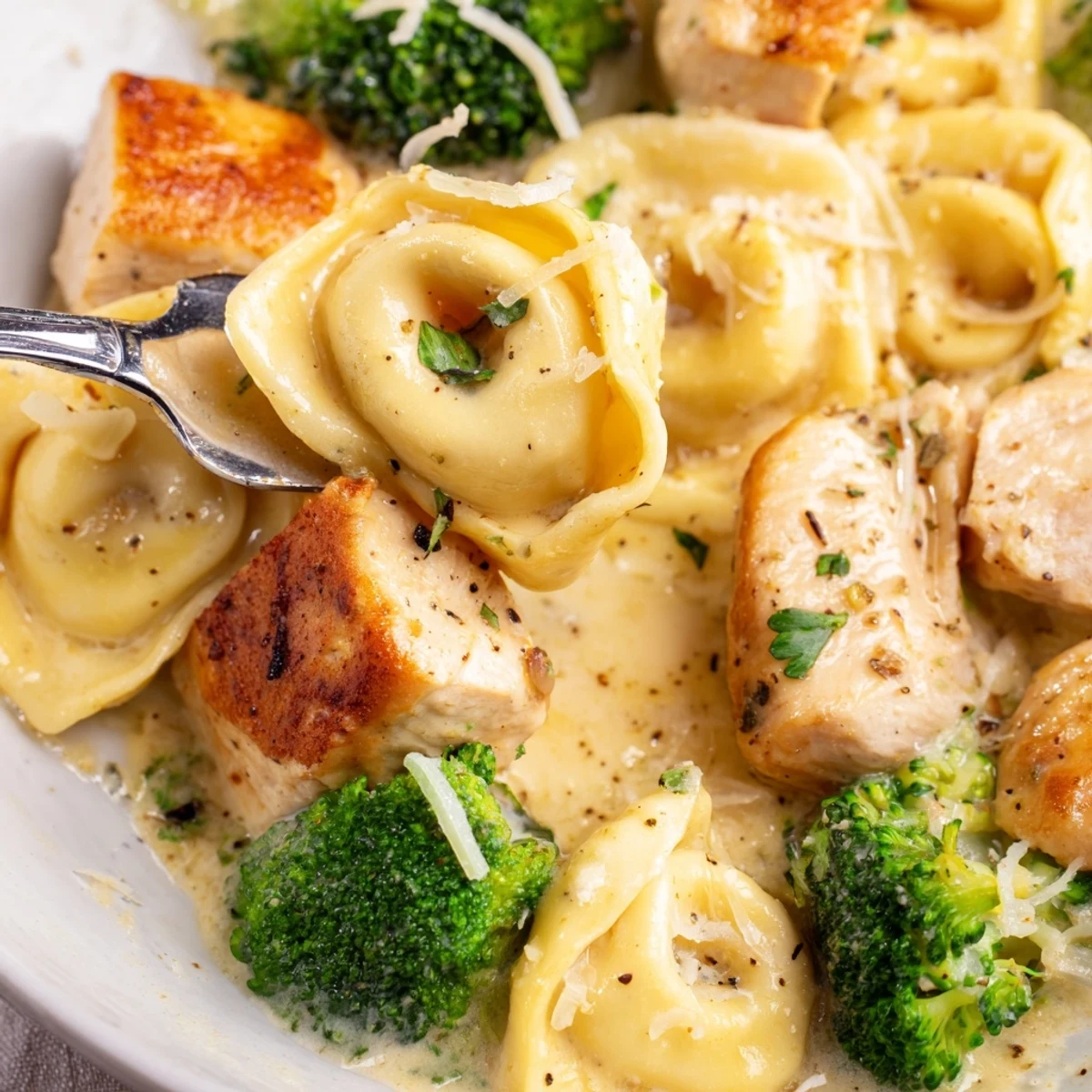 Spoonful of Creamy Garlic Parmesan Tortellini Chicken Broccoli Recipe with tender pasta, crisp broccoli