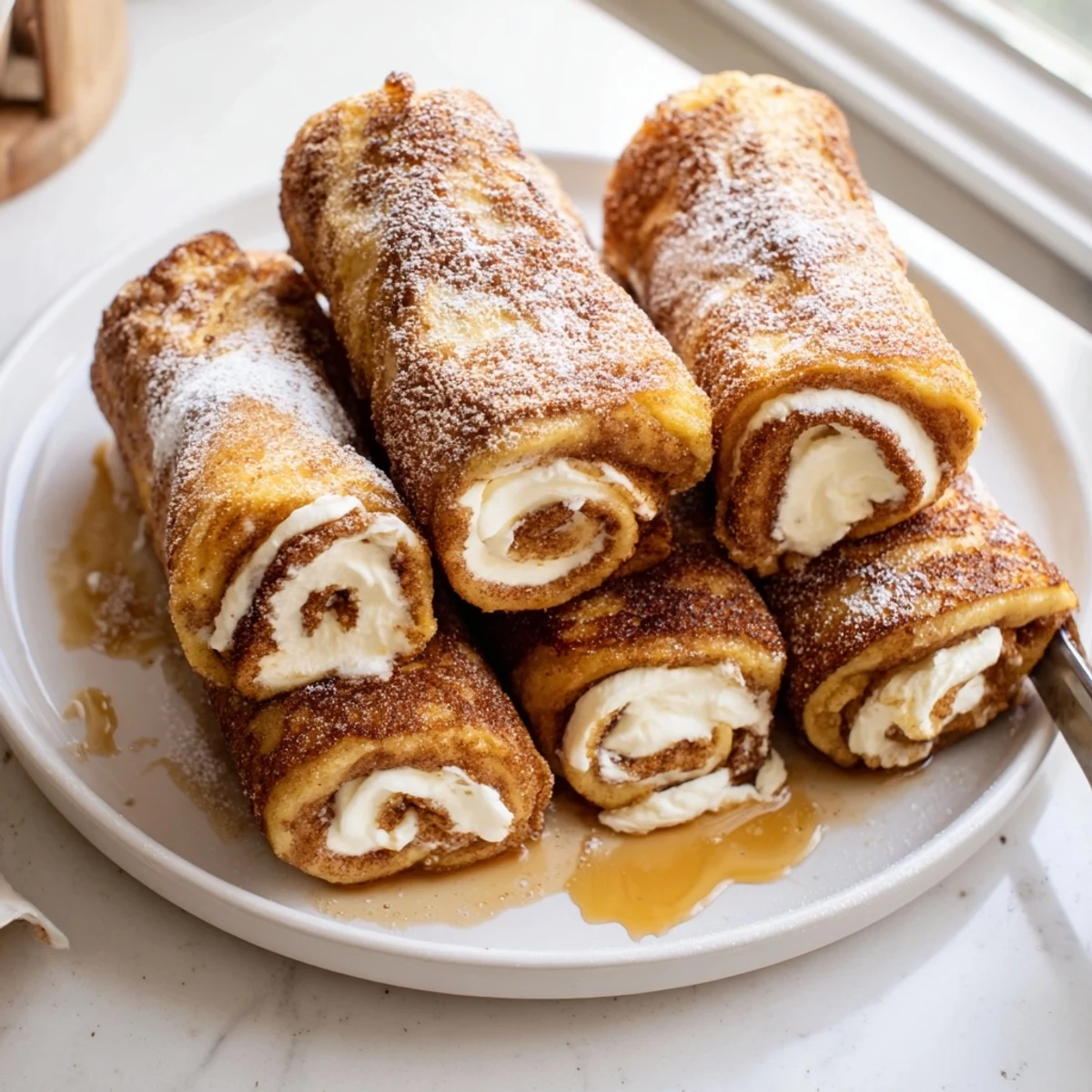 Cinnamon Roll French Toast Roll Ups on plate, golden, cinnamon-sugar crust.