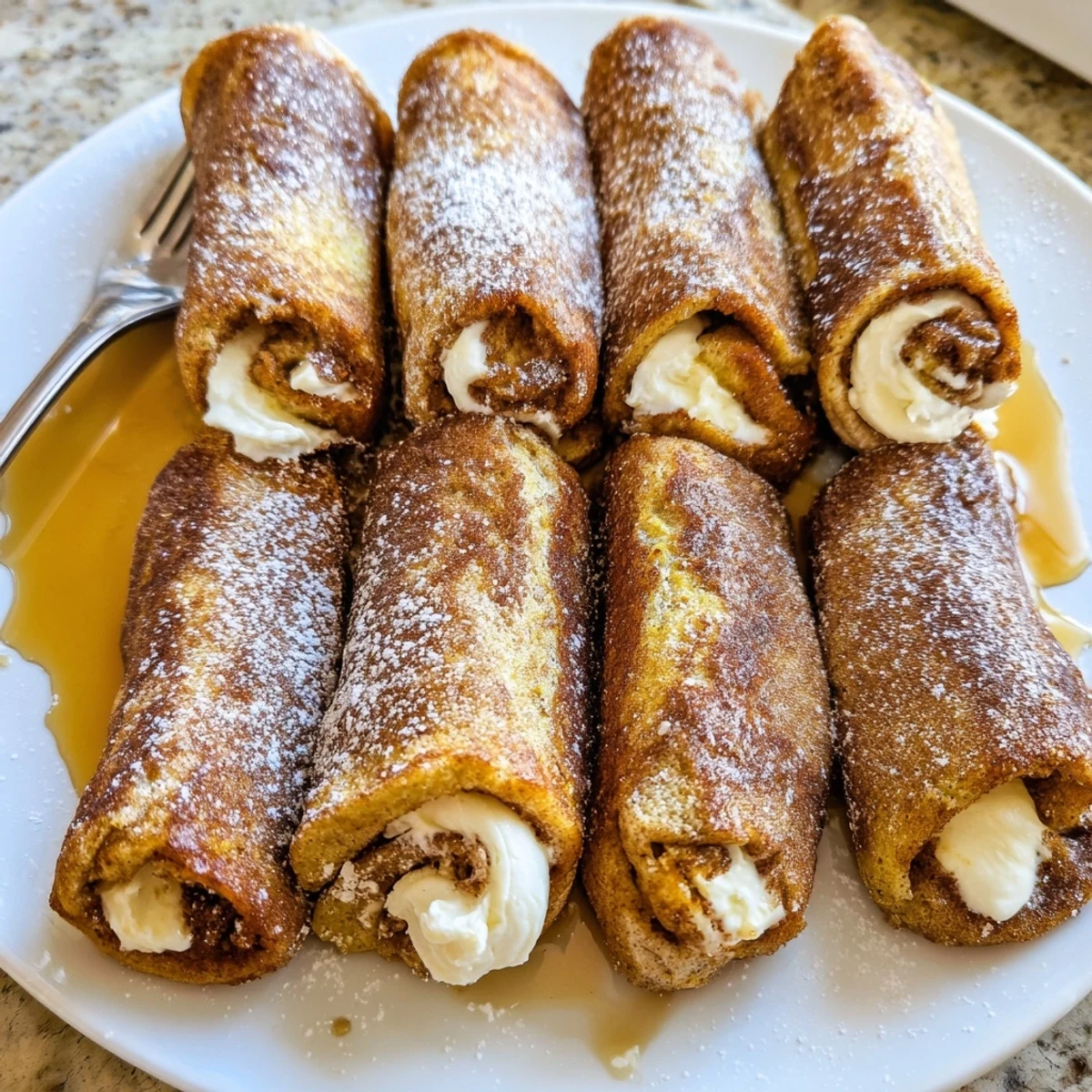 Cinnamon Roll French Toast Roll Ups showing soft cream cheese center, skillet fried.