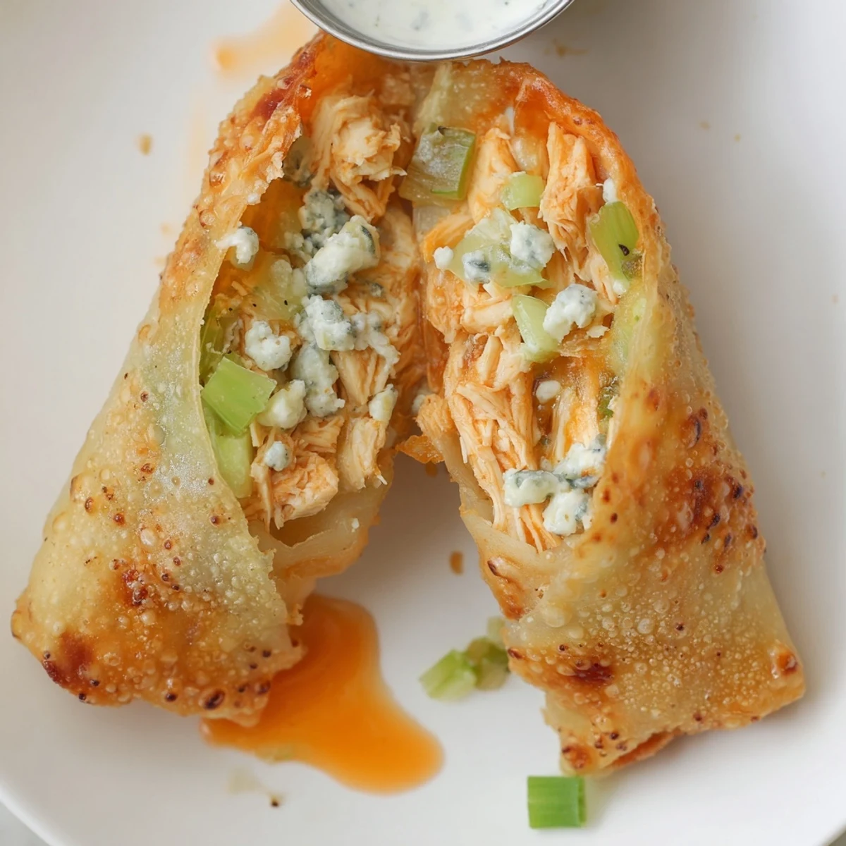 Golden-fried Buffalo Chicken Egg Rolls, spicy filling with celery crunch, blue cheese optional