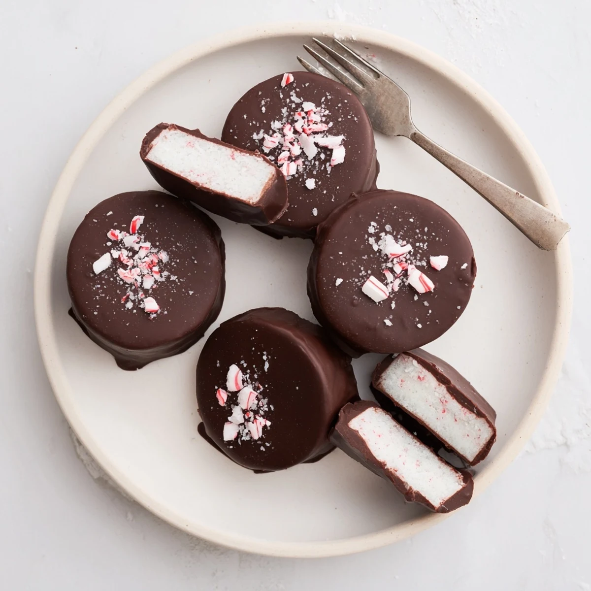 Homemade Peppermint Patties dusted with crushed candy, cool mint bite.