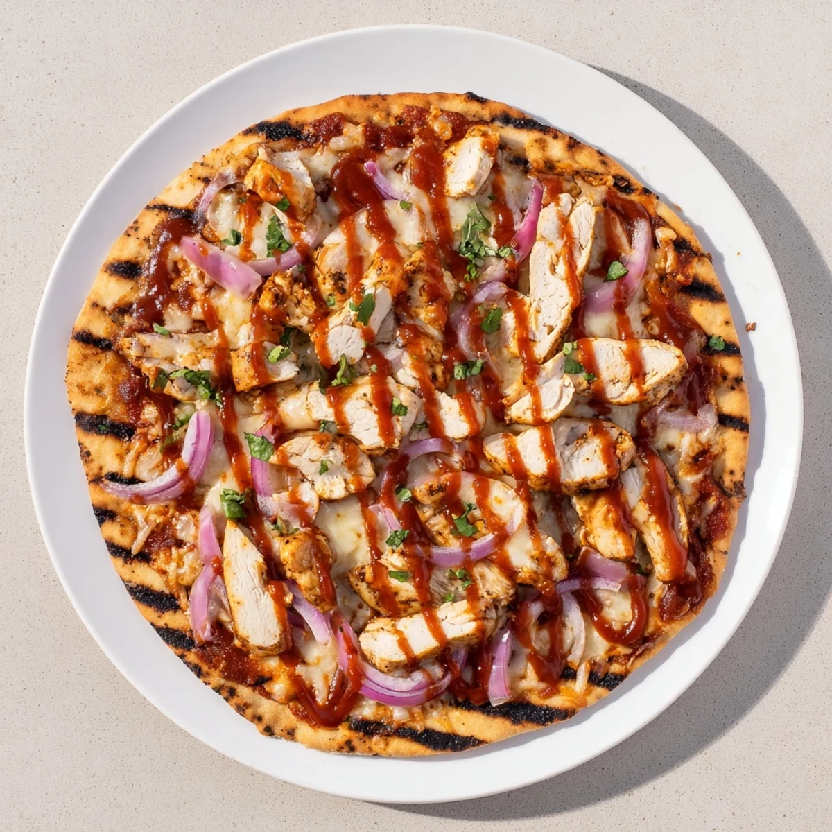 Golden grilled BBQ chicken pizza with melted mozzarella, red onions, and fresh cilantro on a crispy charred crust