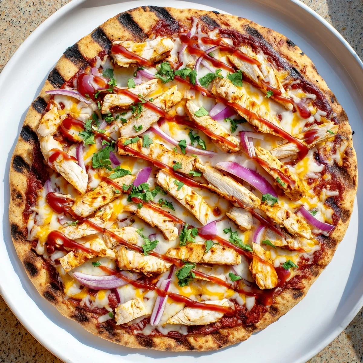 Sliced grilled chicken atop bubbling BBQ sauce and smoked gouda cheese on this smoky homemade grilled BBQ chicken pizza