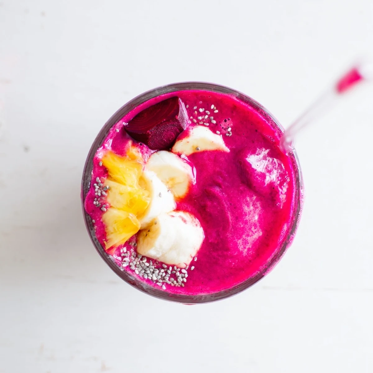 Thick and luscious magenta beet smoothie garnished with chia seeds and served with a colorful straw