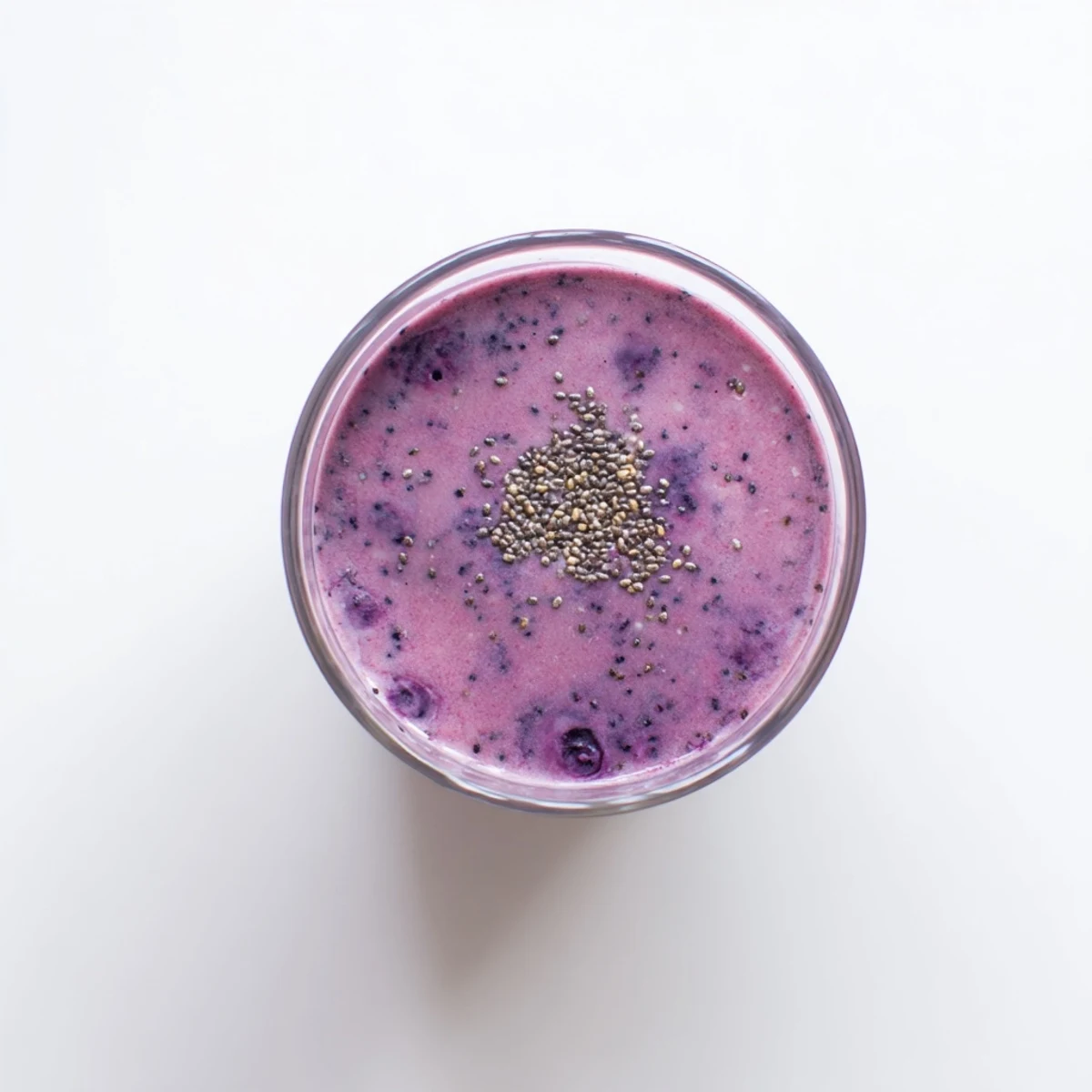 Vibrant purple chia seed smoothie garnished with extra seeds and sliced banana