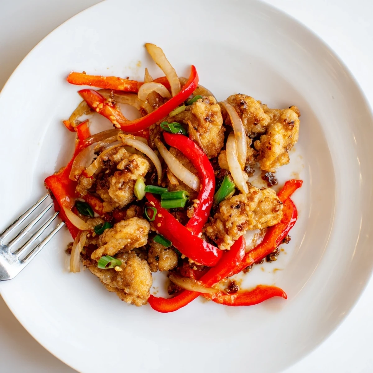 Golden crispy pepper chicken pieces tossed with bell peppers in a savory black pepper sauce
