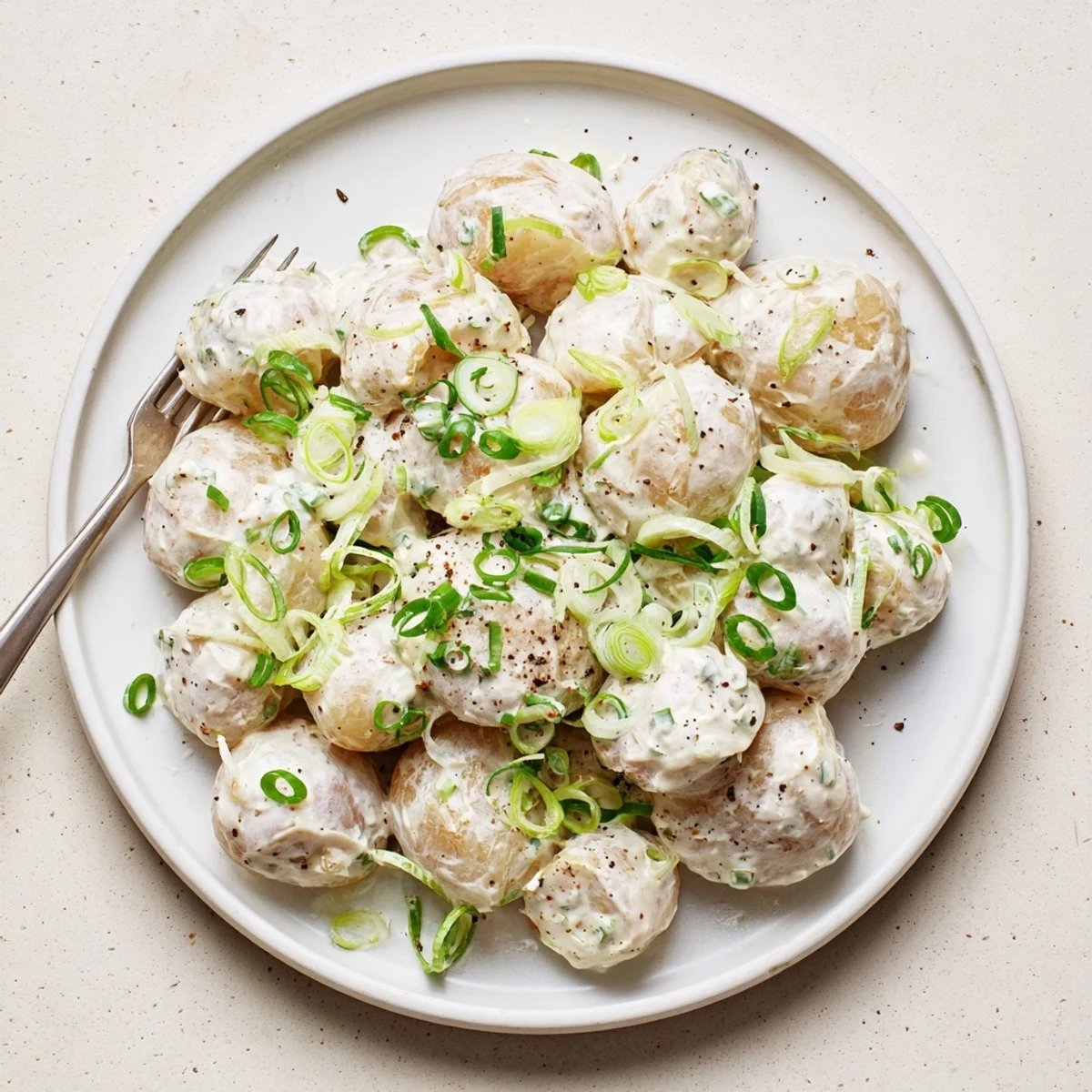 Sour Cream And Onion Potato Salad glistening with creamy dressing and fresh chives