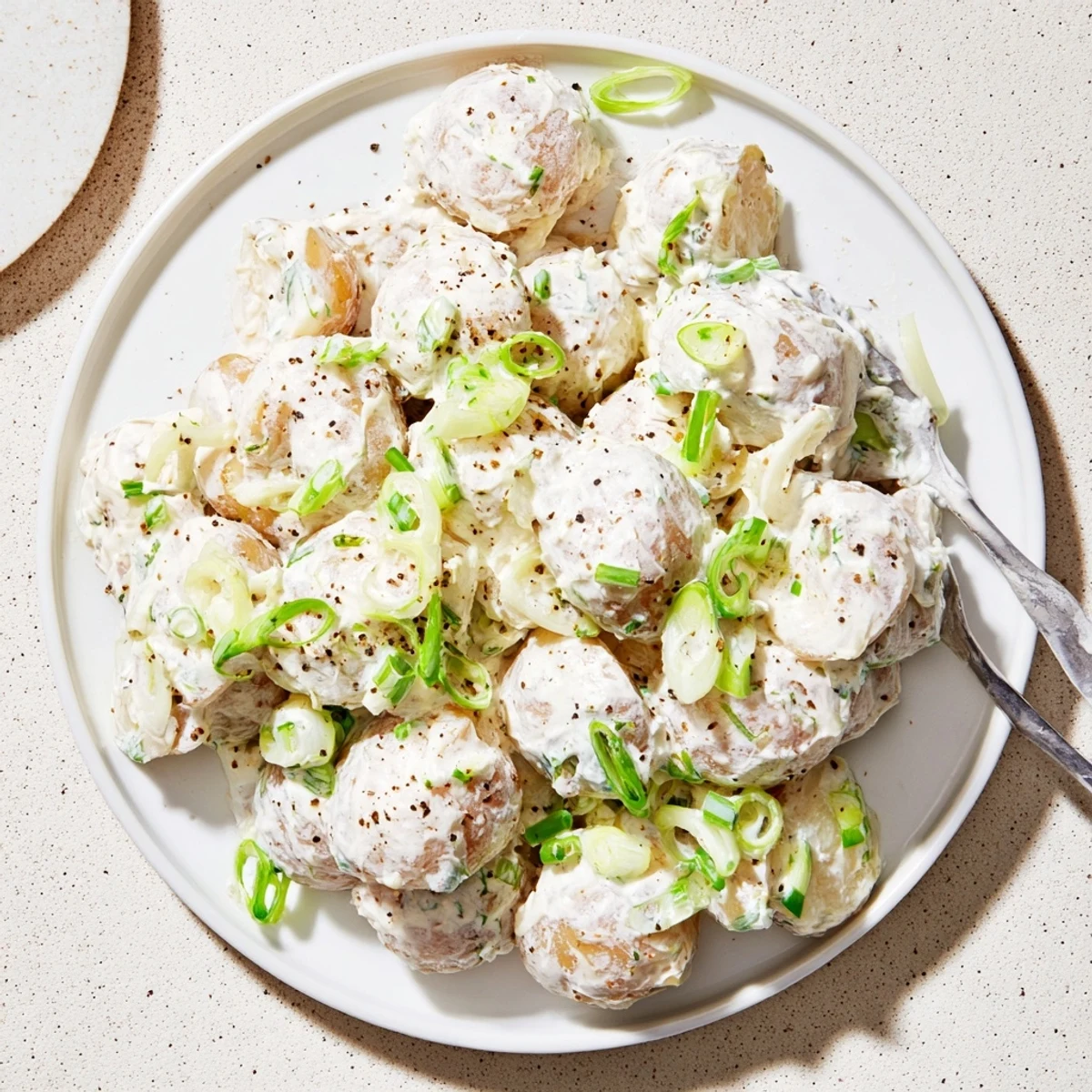 A chilled Sour Cream And Onion Potato Salad alongside smoky grilled chicken