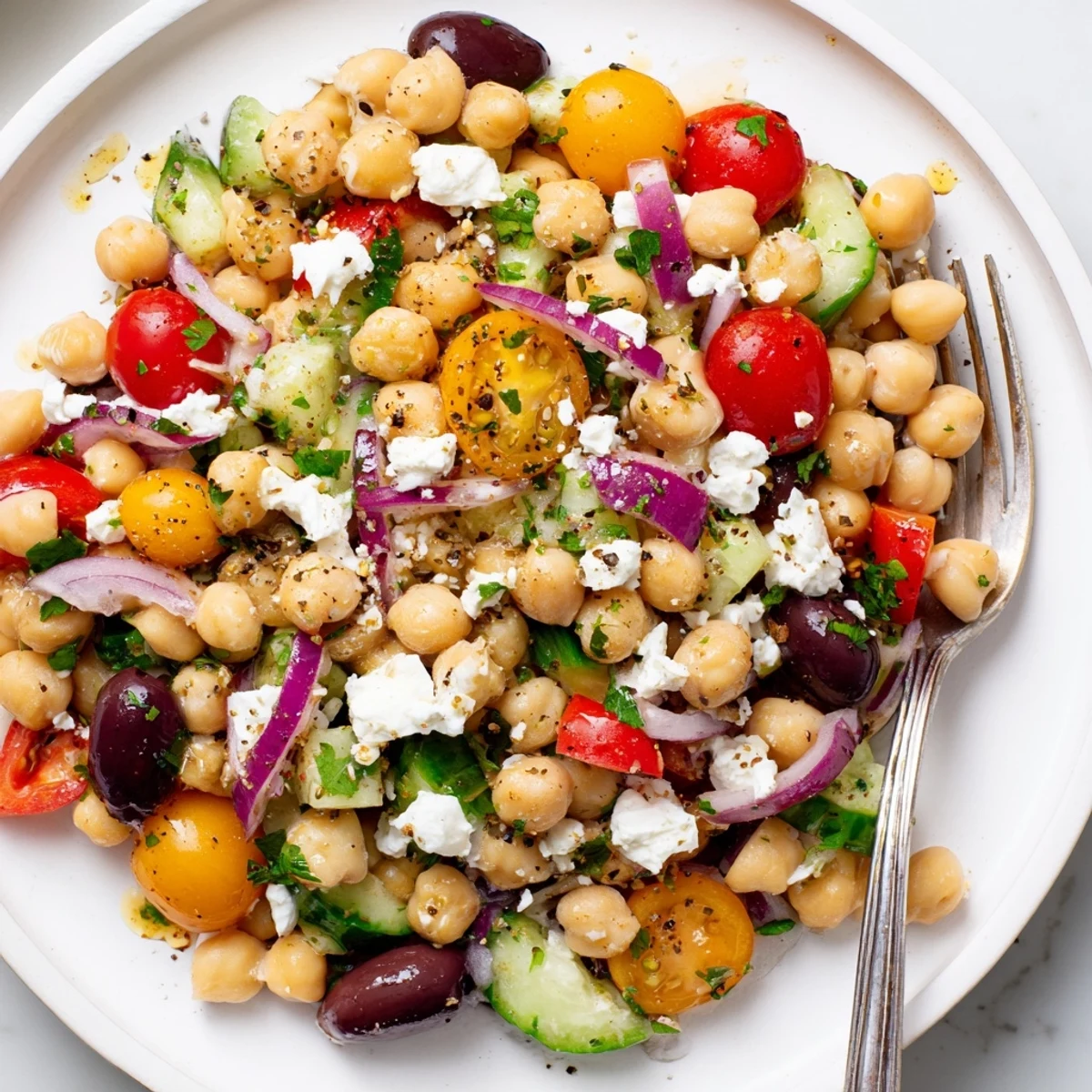 Bright Mediterranean Chickpea Salad Recipe with juicy tomatoes, cucumber, and herbs.