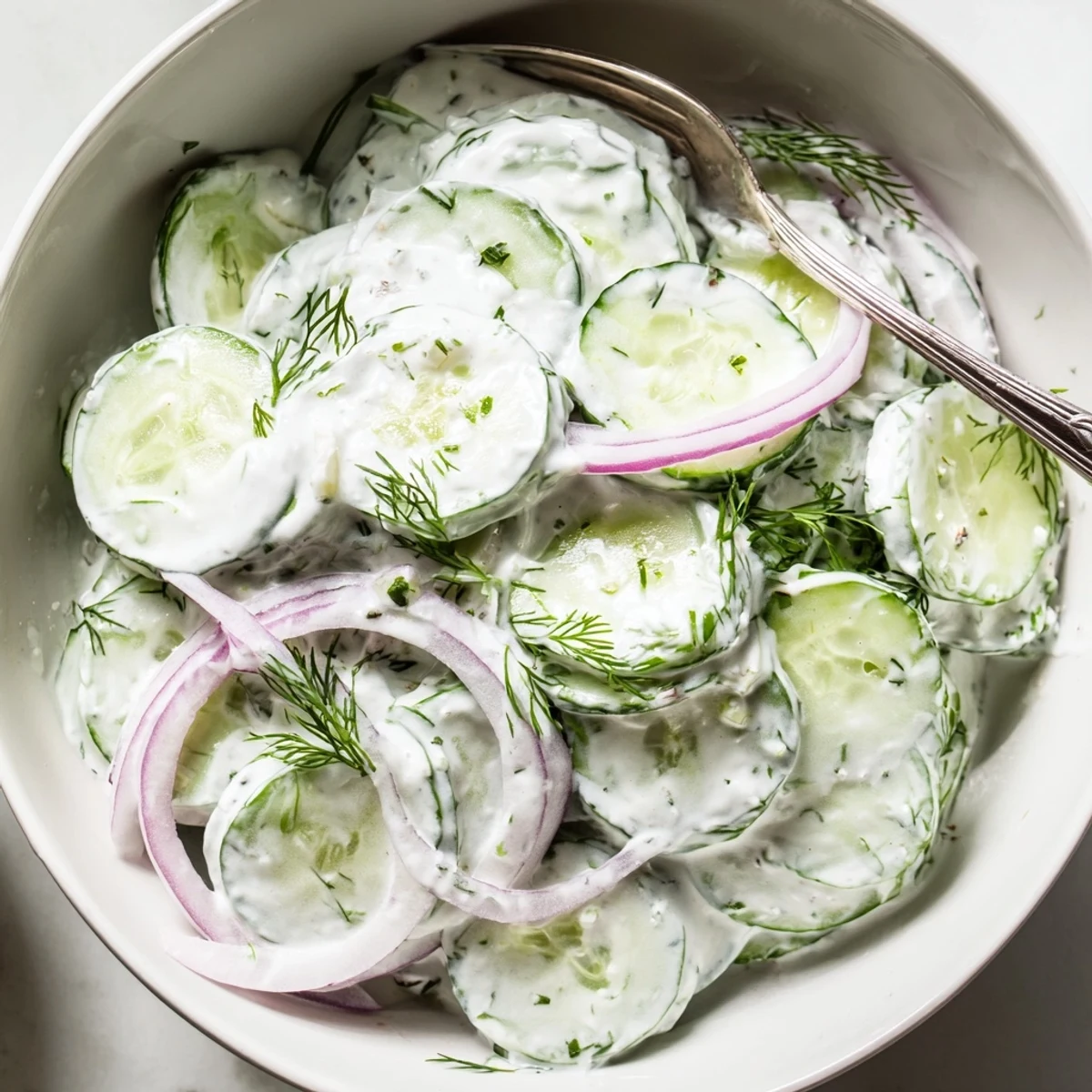 Simple Greek Yogurt Cucumber Salad tossed by hand, tangy lemon and garlic