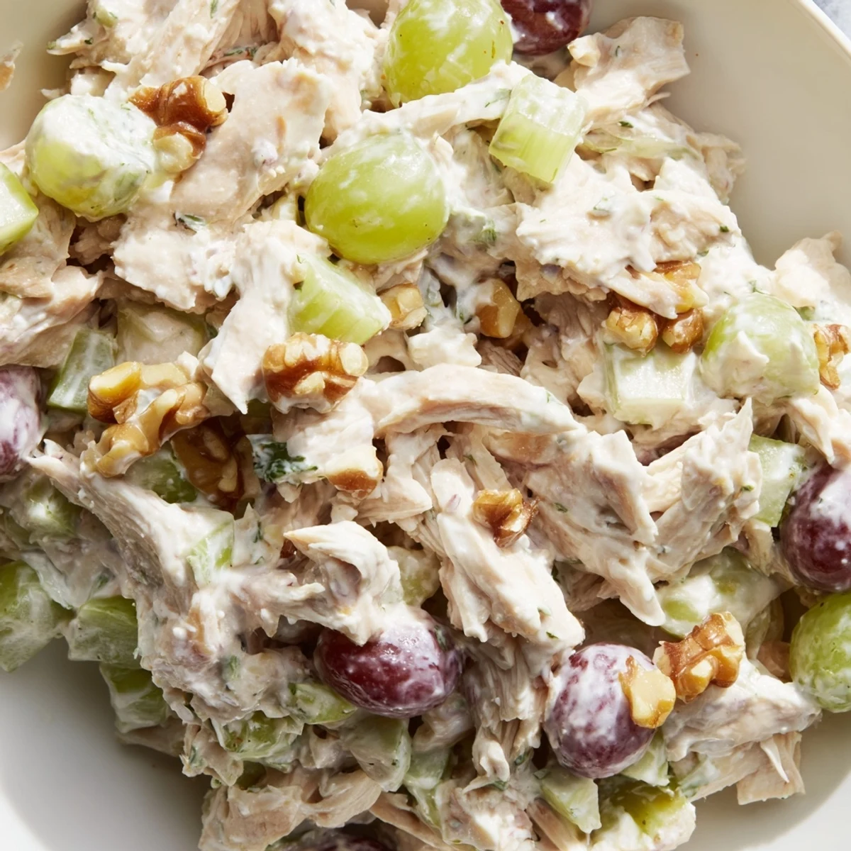 Light chicken salad with tangy yogurt dressing served over mixed greens with celery, grapes, and crunchy walnuts for a refreshing meal