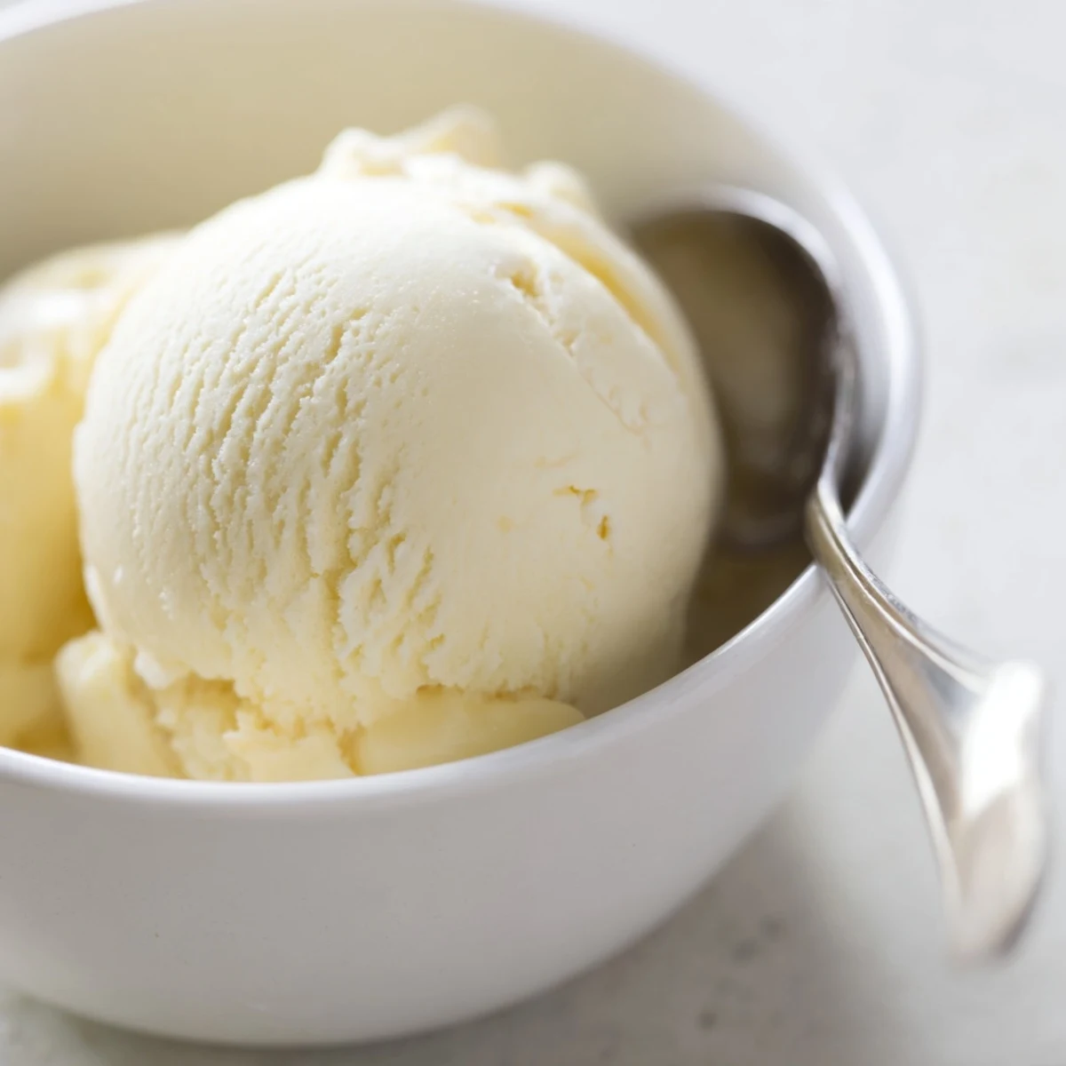 Creamy homemade vanilla ice cream recipe in a chilled glass bowl with soft scoop