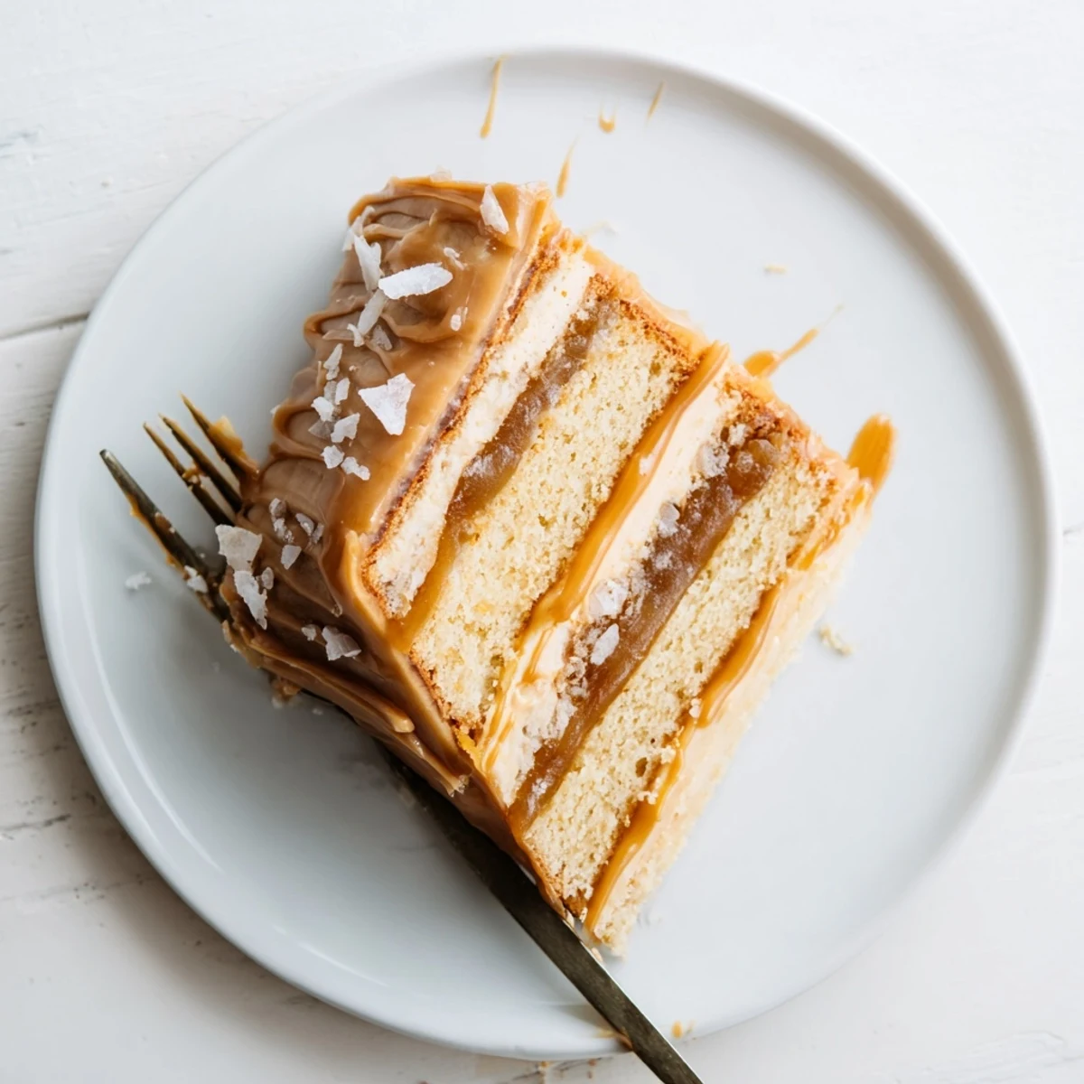 Golden brown butter banana cake drizzled with glossy salted caramel sauce and topped with creamy caramel frosting