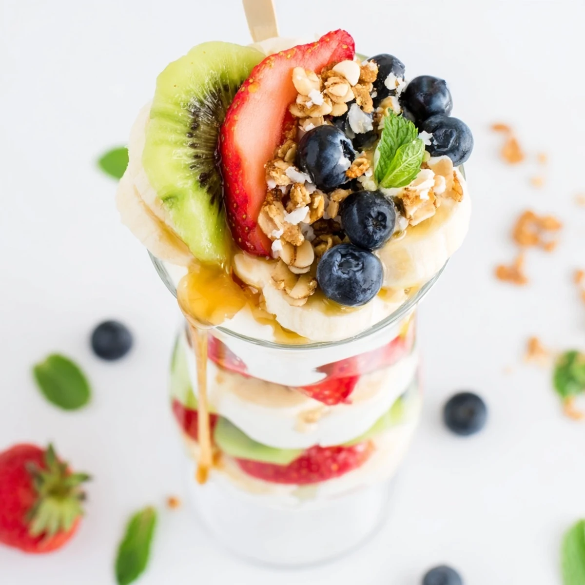 Healthy breakfast parfait recipe featuring alternating layers of yogurt, sweet honey, and vibrant fresh fruit medley
