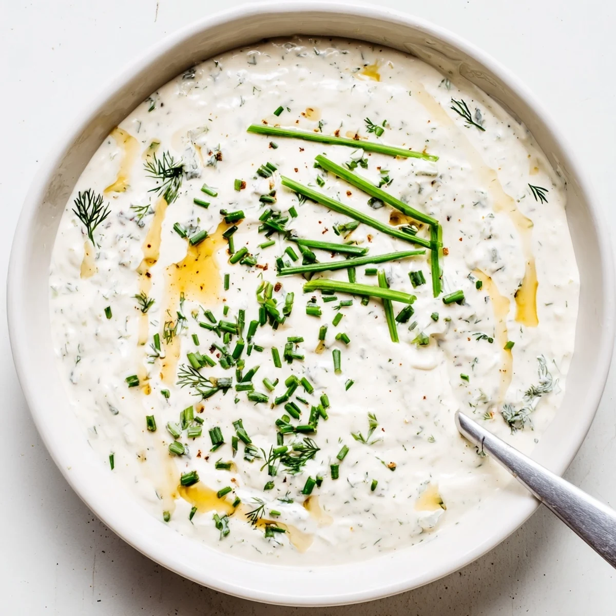 Creamy Hot Honey Ranch Dip in bowl drizzled with honey and fresh herbs