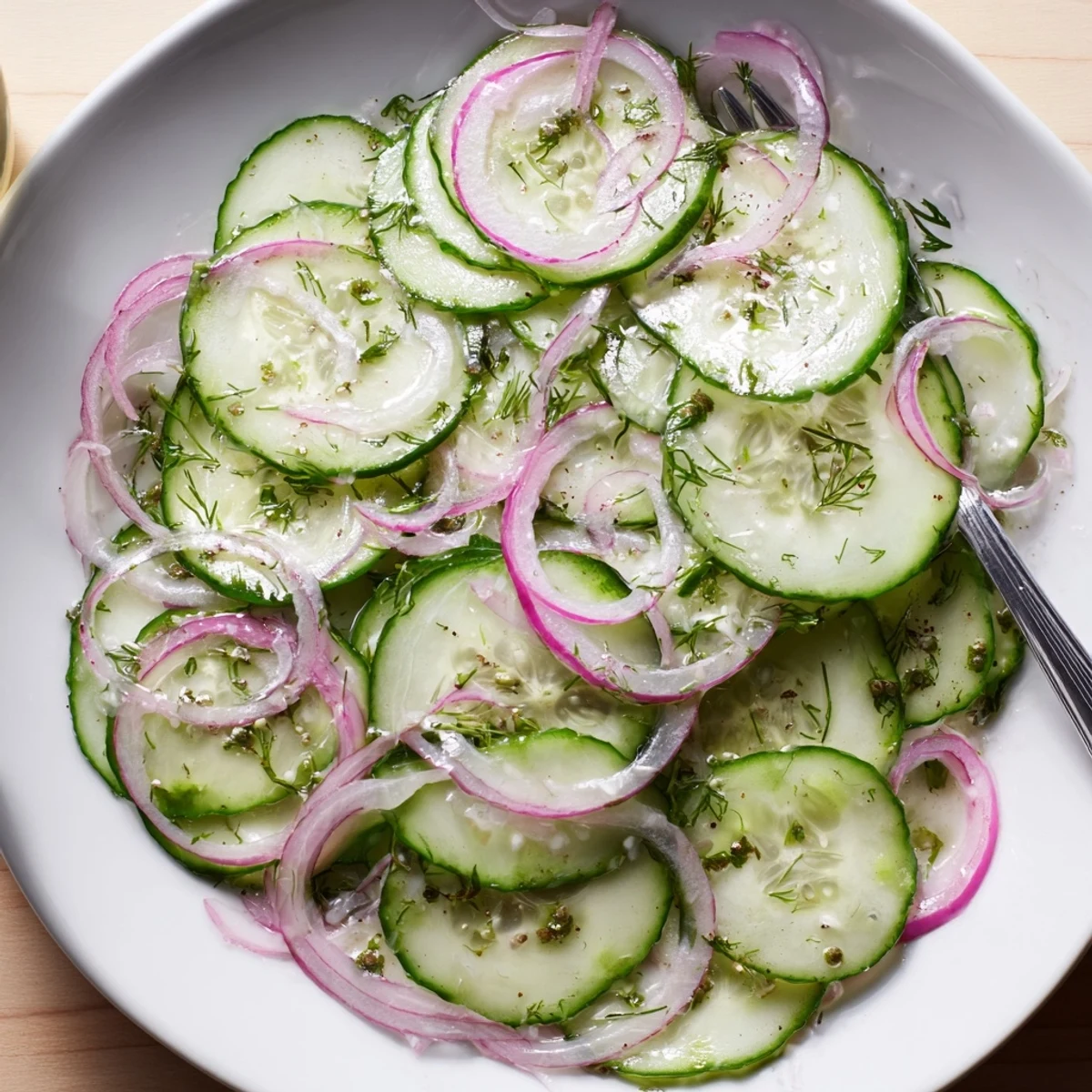 Bright Cucumber Salad tossed with red onion, fresh dill, zesty vinegar dressing.  