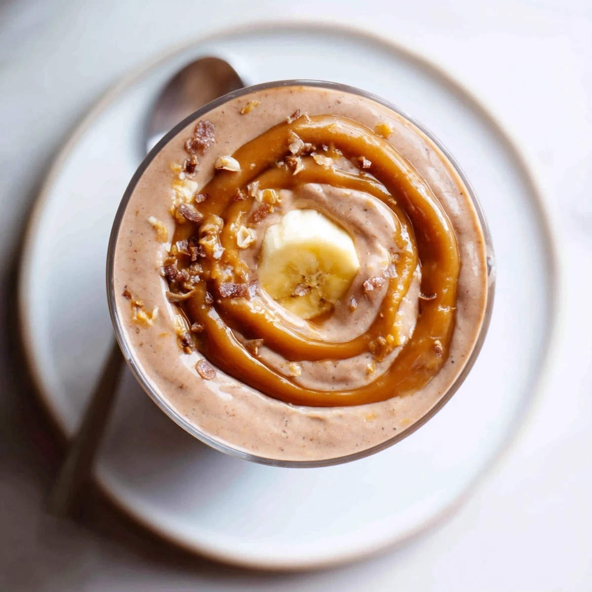 Glass of Salted Caramel Protein Smoothie with caramel drizzle and sea salt