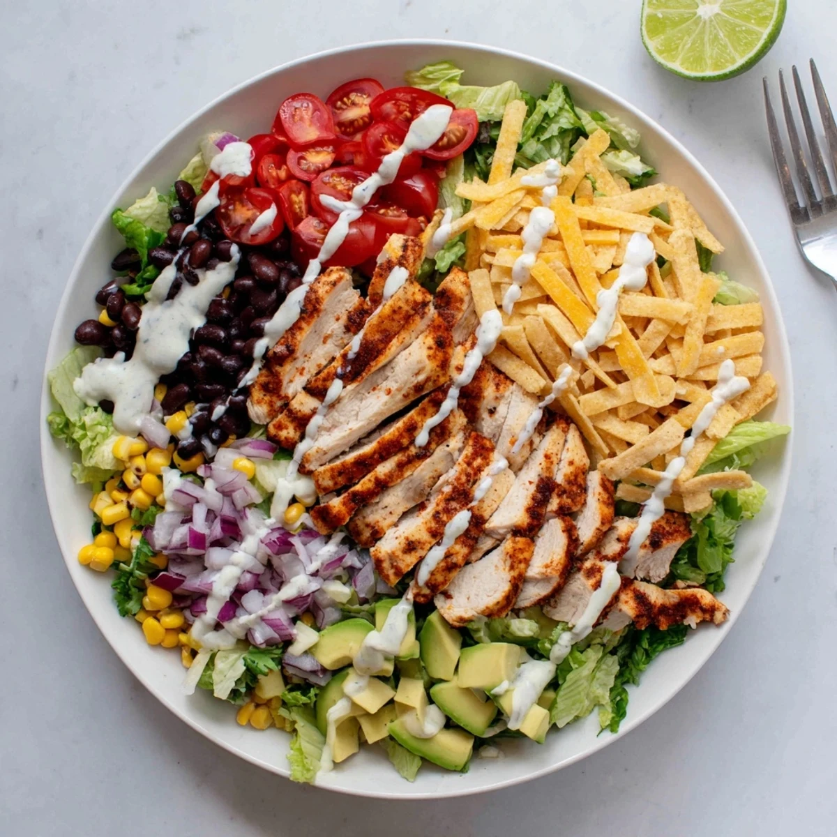 Colorful Southwestern chicken salad bowl topped with sliced grilled chicken and fresh vegetables