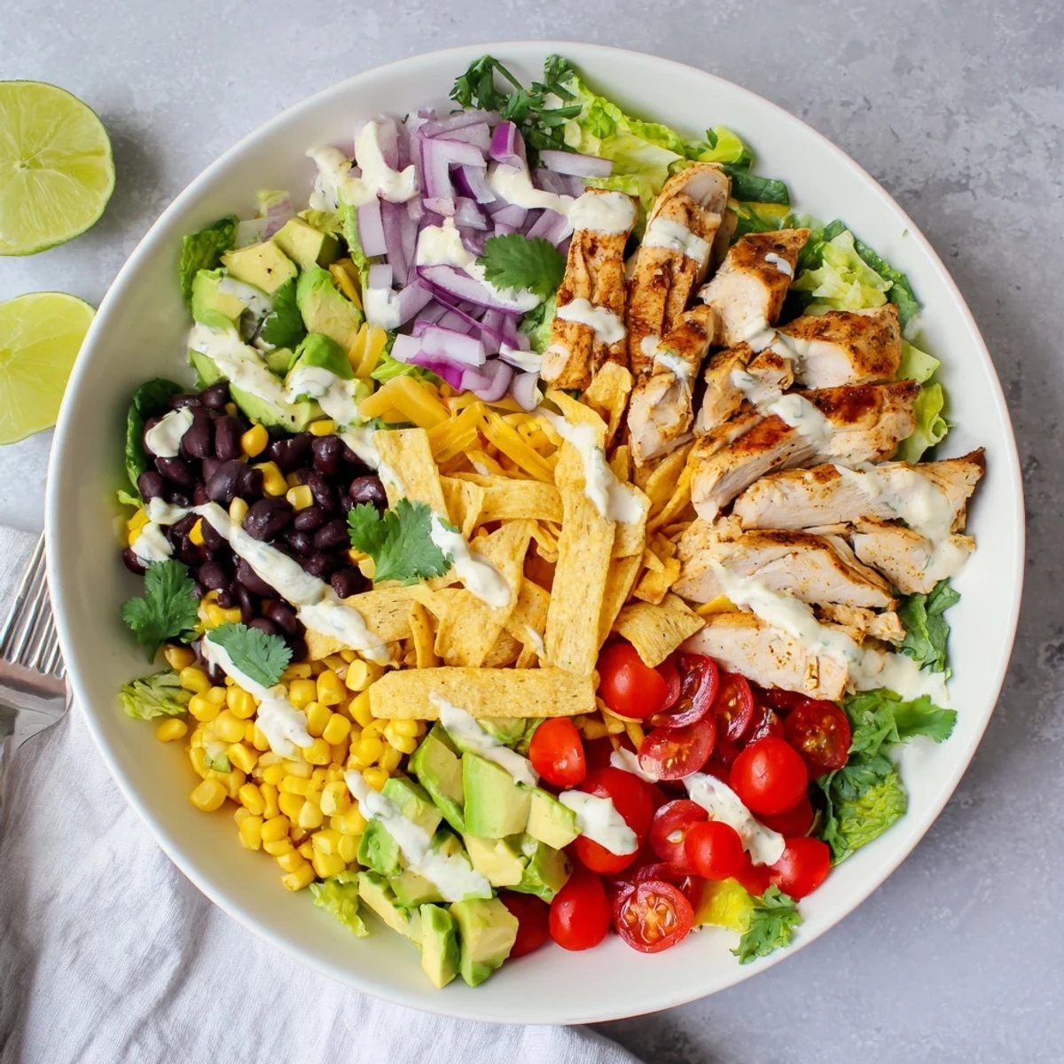 Rustic wooden serving board displaying Southwest chicken salad with avocado and creamy lime dressing